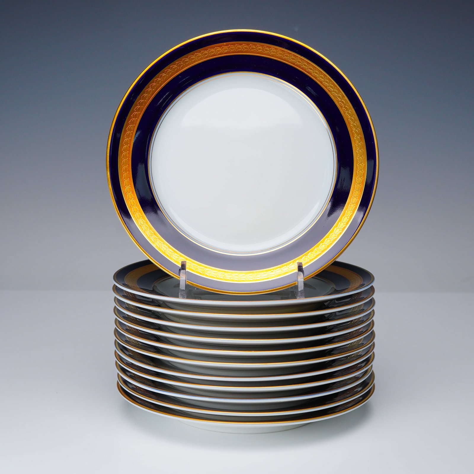 12pc Rosenthal Bread and Butter Plates, Eminence Cobalt Blue: A set of twelve Rosenthal bread and butter plates in the Eminence pattern, each with a cobalt blue band, gold inner border, and white center. All plates carry the Rosenthal Germany backstamp and numbe