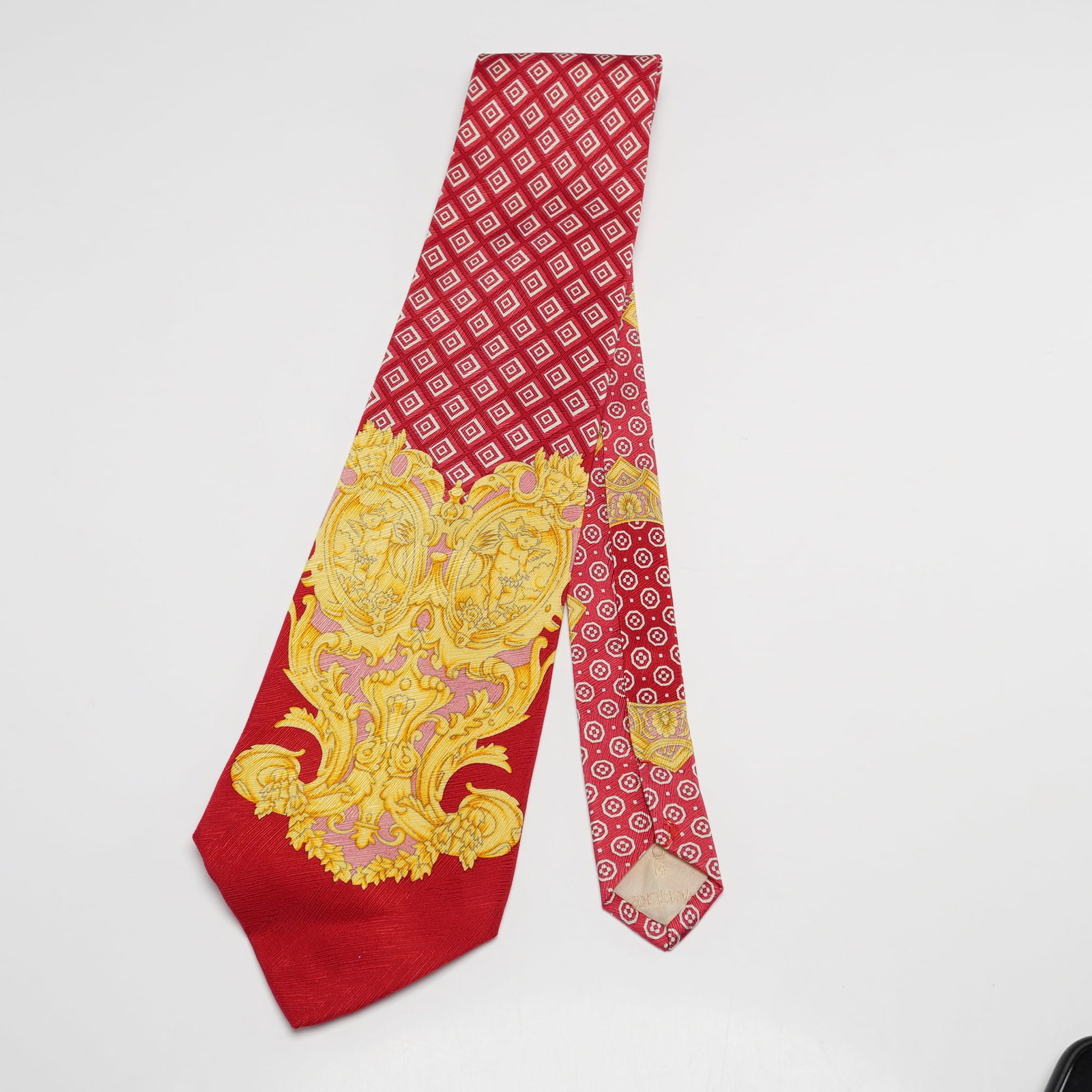 Gianni Versace Silk Necktie Red Baroque Pattern: Gianni Versace pure silk necktie featuring a vivid red ground with ornate gold baroque motifs and contrasting geometric patterning, finished with a light gold Versace branded lining on the back. Dimen