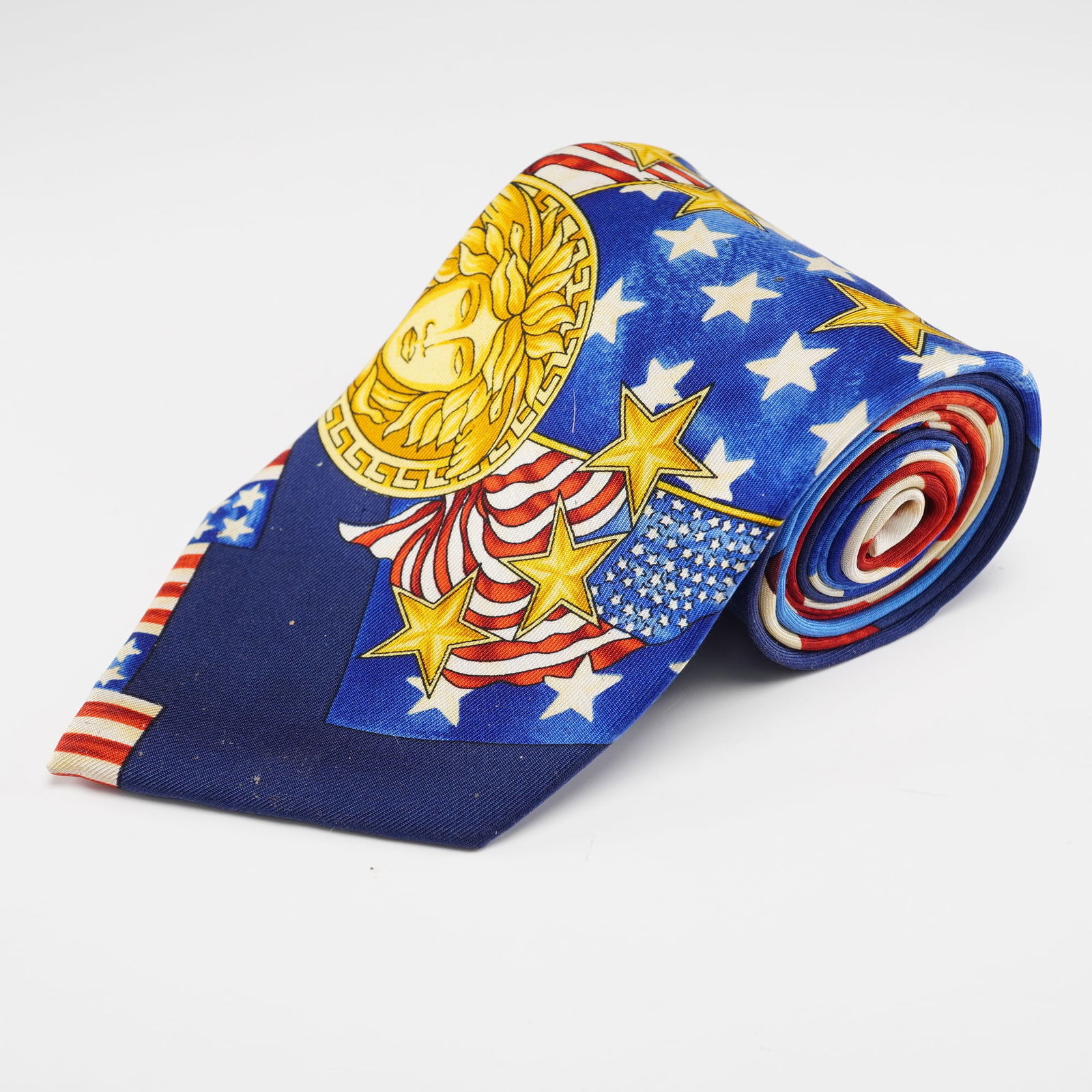 Gianni Versace Silk Necktie Patriotic Medusa Design: Gianni Versace pure silk necktie featuring a bold patriotic theme with stars, stripes, and American flag motifs surrounding the signature Medusa emblem, all set against a deep blue ground, with the Gi