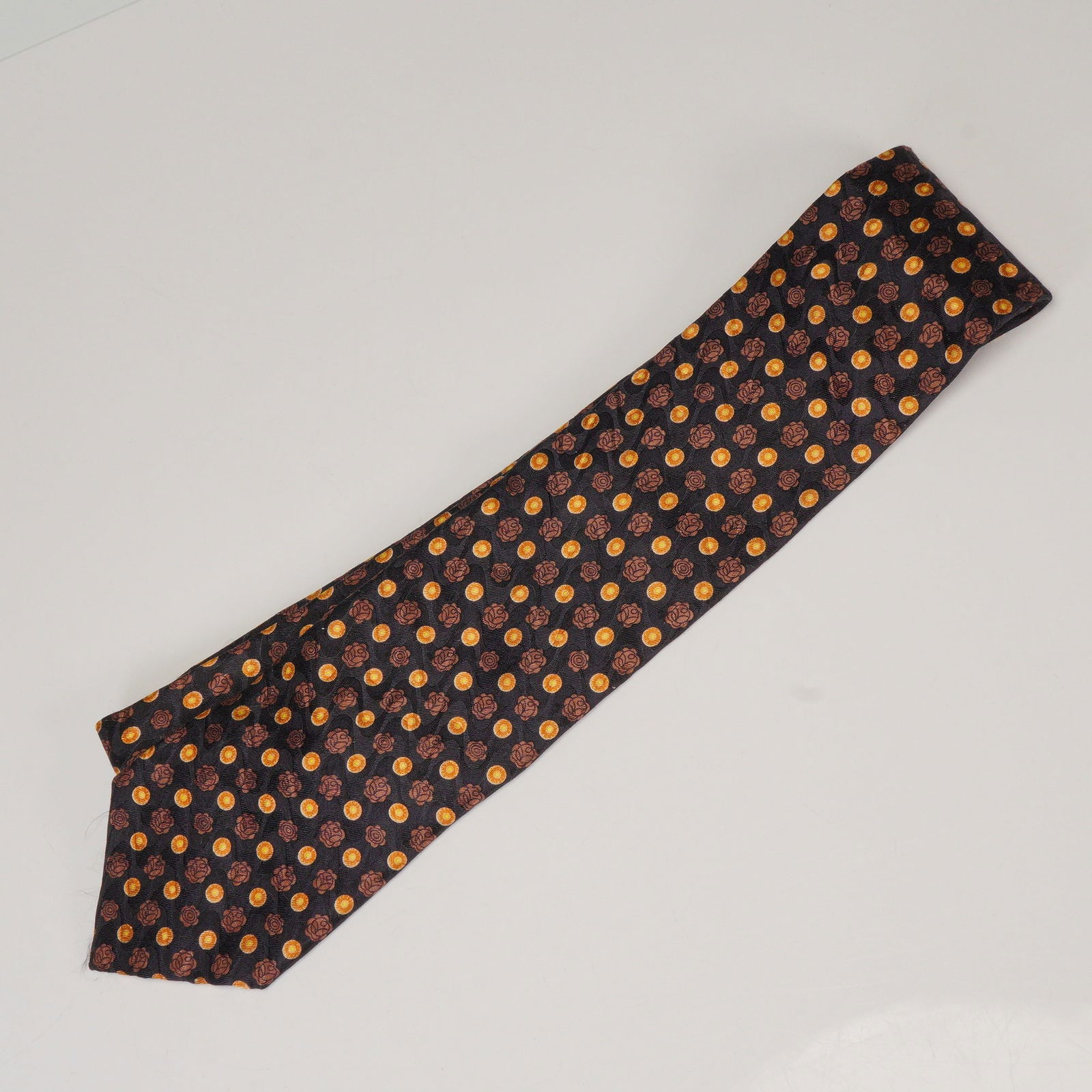 Ermenegildo Zegna Brown and Gold Silk Tie: Elegant 100% silk tie by Ermenegildo Zegna featuring a rich brown background with a repeating geometric motif of gold and rust circular accents. Finely crafted in Italy, this classic accessory combine