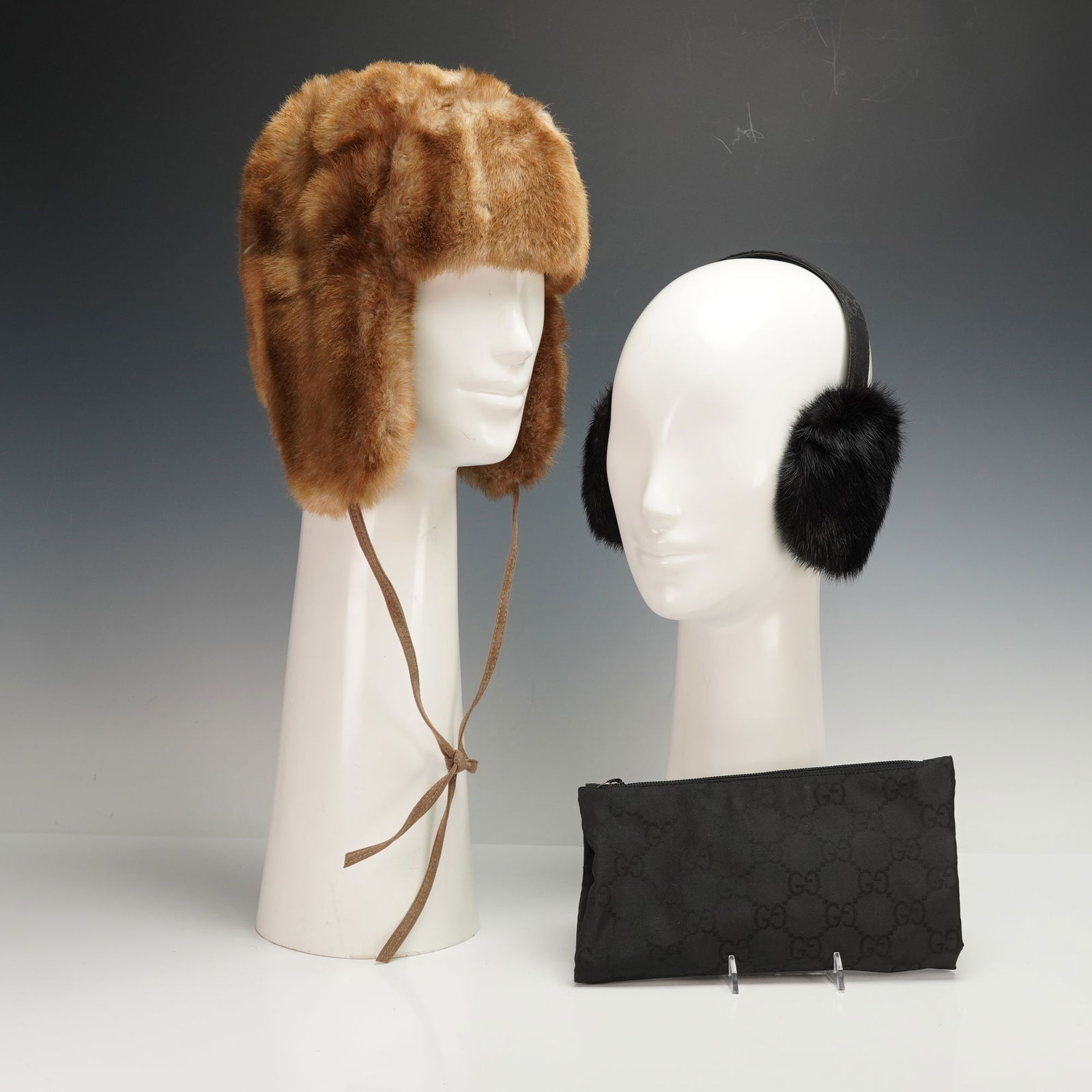 2pc Gucci and La Maison De La Fausse Fourrure Earmuffs with Case and Hat: Two piece set featuring black Gucci earmuffs with a GG patterned headband and included matching GG zip case, paired with a tan La Maison De La Fausse Fourrure winter hat with ear flaps and tie closure