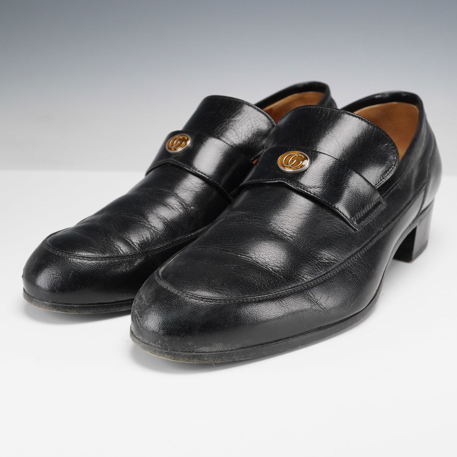 Gucci Men's Black Leather Loafers, Gucci Team: Made in Italy, these striking Gucci loafers feature smooth black leather uppers with gold-tone GG emblems across the straps. The insoles and soles are both stamped with the Gucci hallmark. The heels a