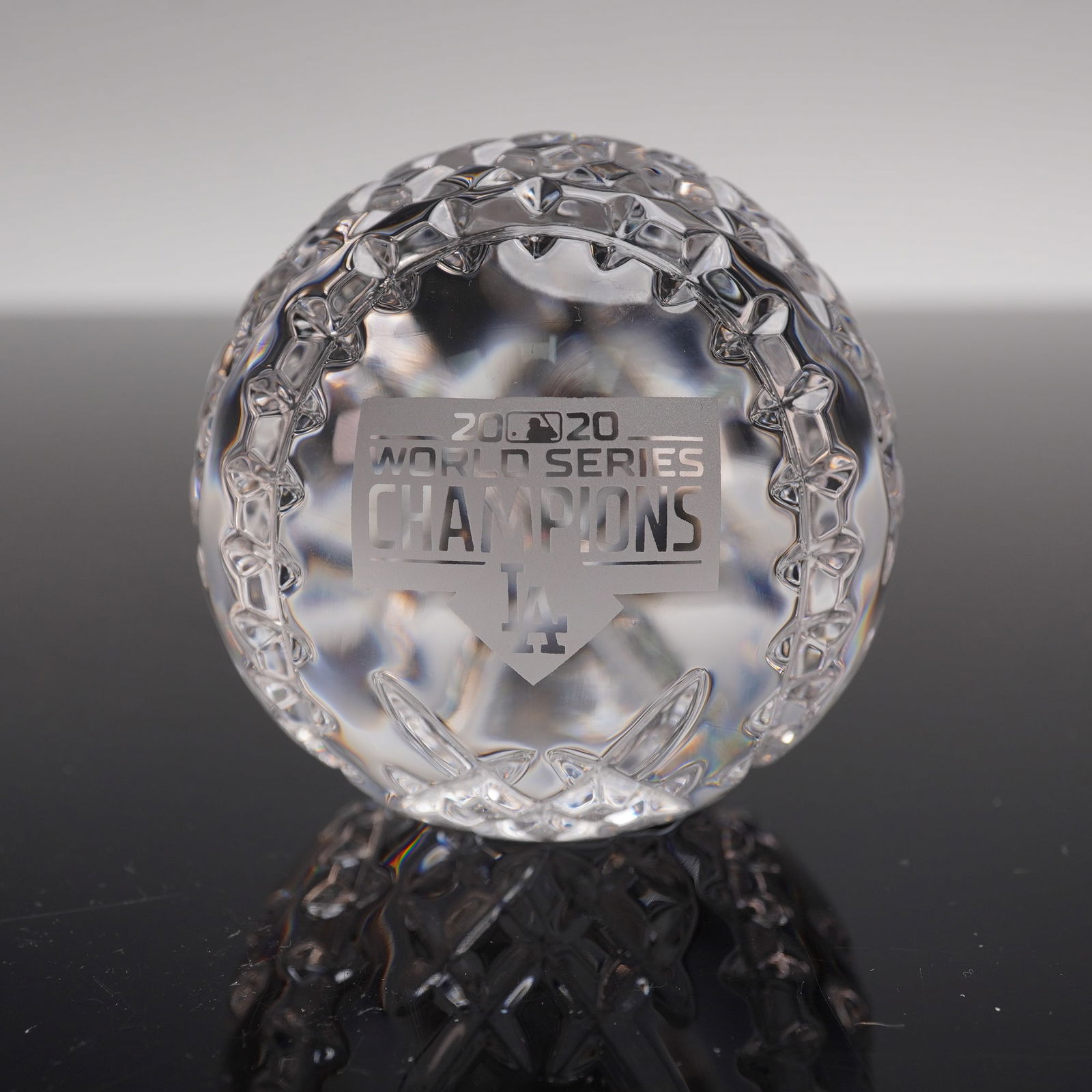 Waterford Crystal 2020 World Series Champions Baseball Paperweight: A limited-edition commemorative piece crafted in fine Waterford crystal, designed in the shape of a baseball with intricate cut patterns and etched details. The front features the "2020 World Series C