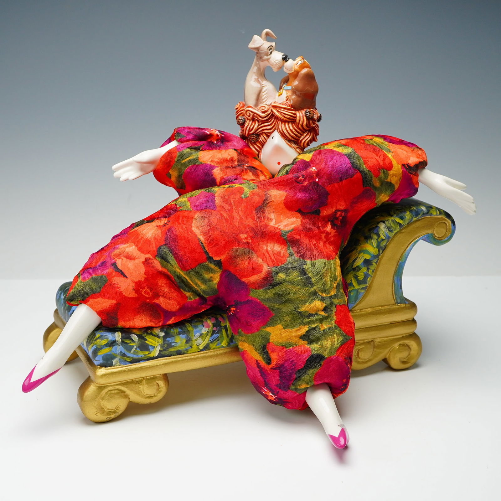 Poupee Millet Disney Lady and the Tramp Doll and Chaise Lounge: This vibrant two piece set features a whimsical Poupee Millet art doll inspired by Disney Lady and the Tramp, posed in an exaggerated reclining position with a bright floral costume and sculpted porce