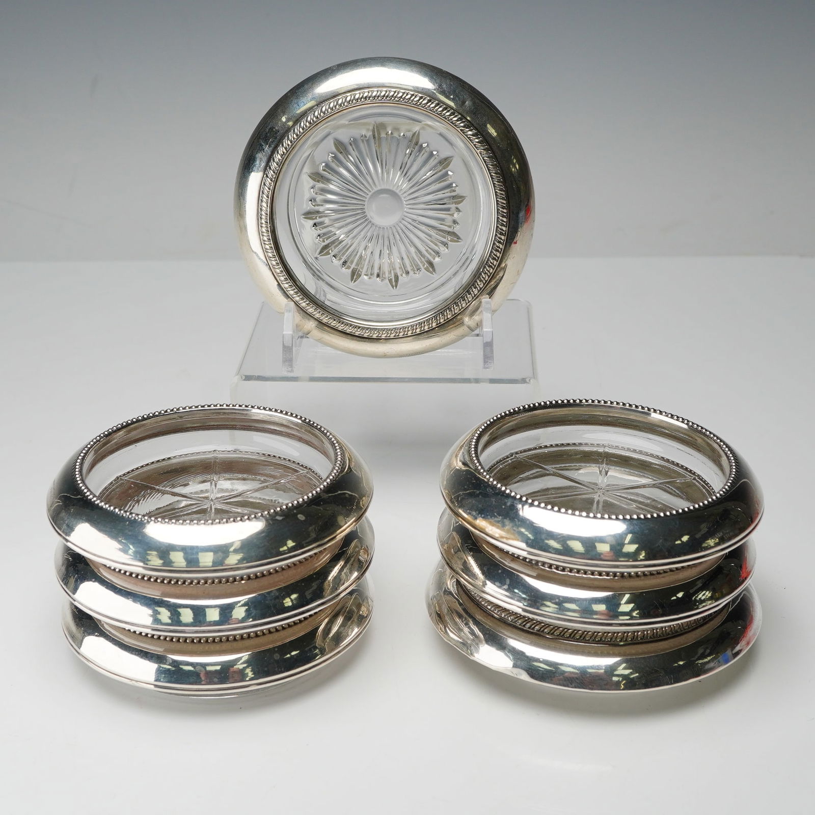 7pc Frank M Whiting & Co. and Paben Sterling Silver Glass Coasters: This collection features five Frank M. Whiting sterling silver coasters, each designed with a classic beaded rim and fitted with glass inserts cut with six radial lines. All pieces bear the Frank M. W