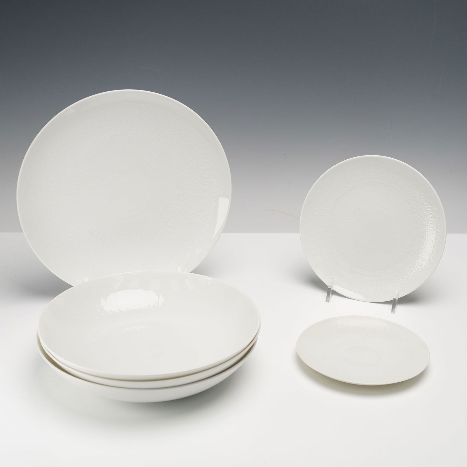 6pc Rosenthal Porcelain Dinnerware, Romance: Porcelain dinnerware pieces, plates and bowls, from Germany, featuring a refined embossed geometric motif in glossy white. The minimalist design exemplifies Rosenthal's celebrated modernist craftsmans