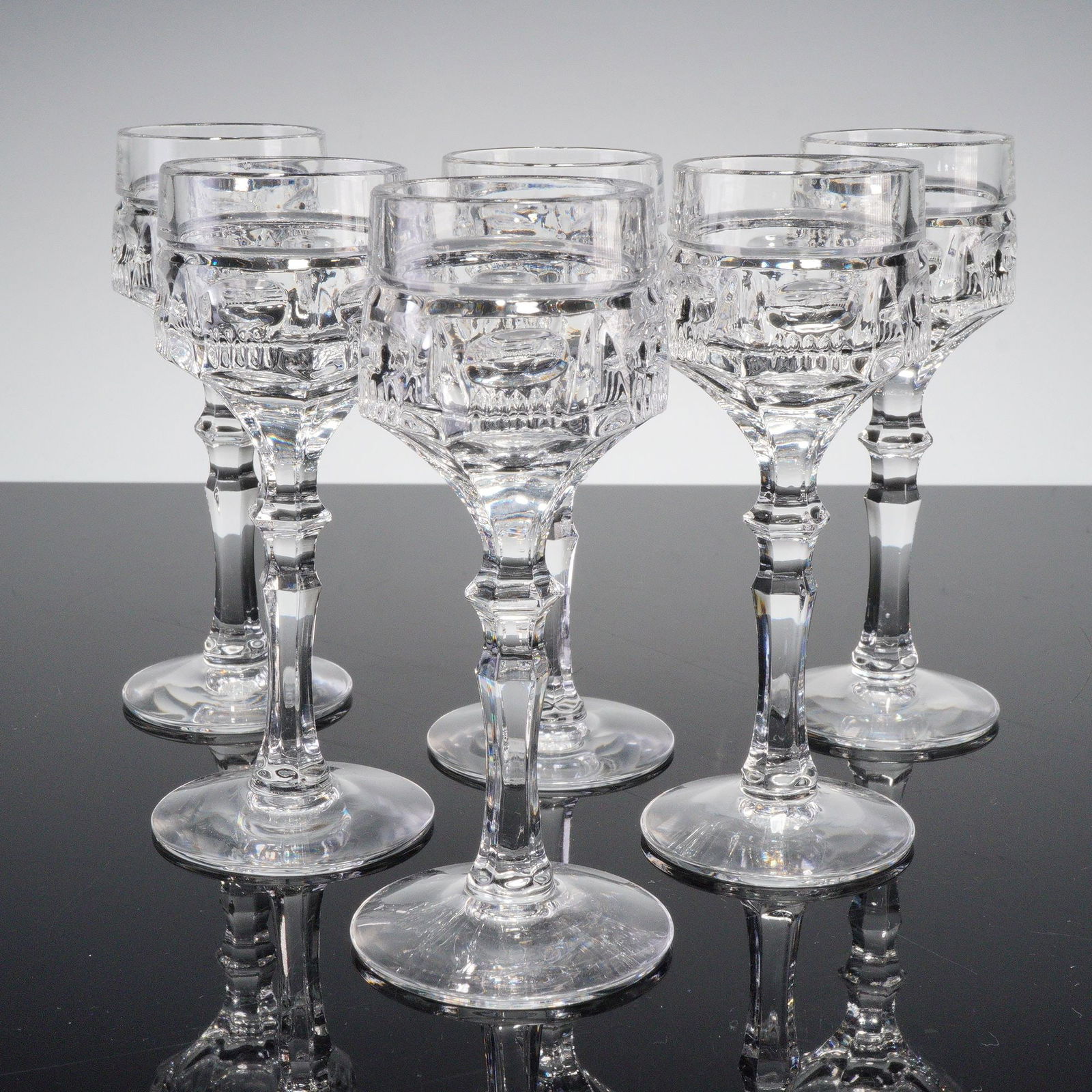 6pc Clear Cut Crystal Cordial Glasses: Set of six finely cut crystal cordial glasses, each featuring beautifully faceted stems and paneled bowls that catch and reflect the light with refined brilliance. Crafted in a timeless European style