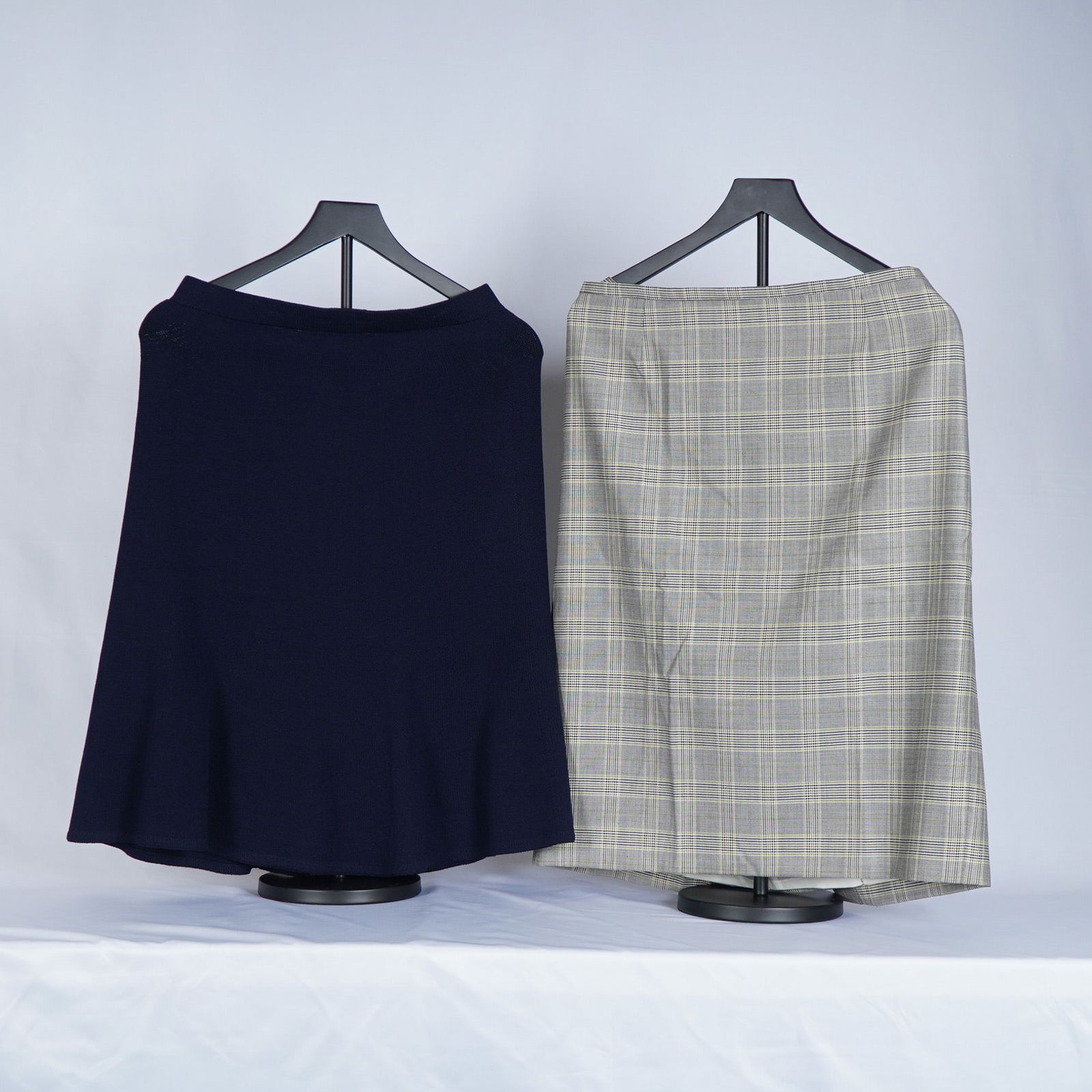 2pc Escada Tartan Pencil Skirt with St. John Wool Knit Skirt: Lot includes classic Escada tartan pencil skirt paired with a St. John Collection wool knit skirt. The Escada skirt presents a refined grey plaid pattern with yellow accents, a structured tailored fit