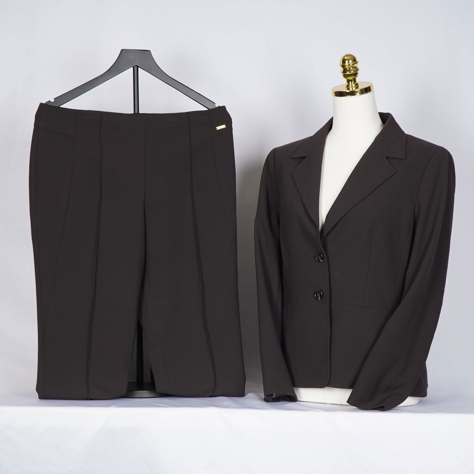 2pc Escada Pant Suit, Chocolate Brown: Escada two-piece brown suit consisting of a tailored jacket and coordinating trousers. The jacket features a two-button front and notched lapels, and the trousers are designed with a flat waistband an