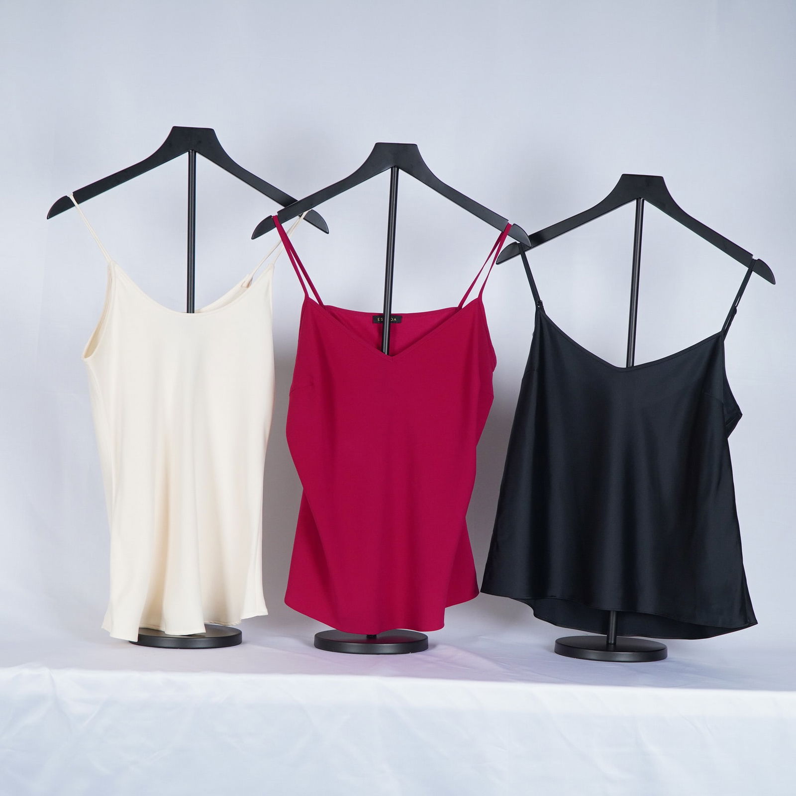 3pc Escada, Giorgio Armani & Tahari Silk Camisoles: Camisoles include a cream silk by Giorgio Armani (Made in Italy, size 16), a red camisole by Escada (size 42), and a classic black camisole by Elie Tahari. Each piece features a fluid drape and slende