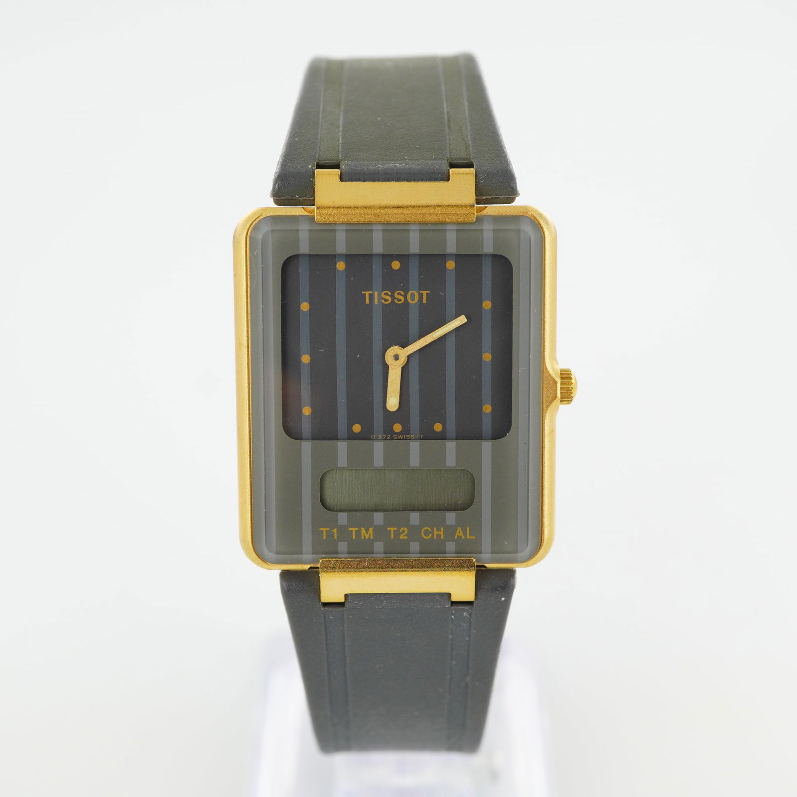 Tissot Two Timer Wrist Watch: Wrist watch featuring a distinctive dual-display design that combines an analog dial with a digital secondary display. The square gold-tone case houses a vertically striped gray dial accented with gol
