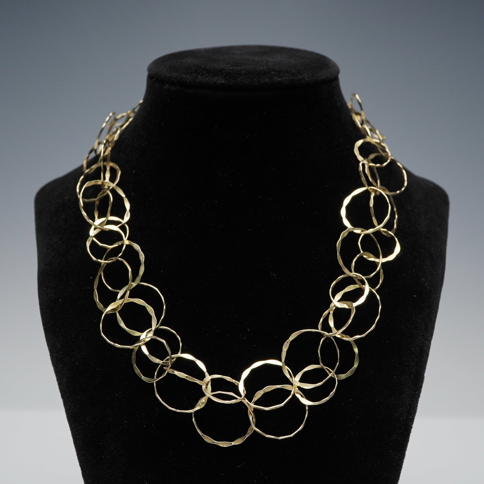 14K Gold Continuous Hammered Open Link Necklace: Crafted in 14K gold, this continuous necklace is composed of interlinked open circular rings with a softly hammered surface. The design forms an unbroken loop without a clasp, allowing it to be slippe