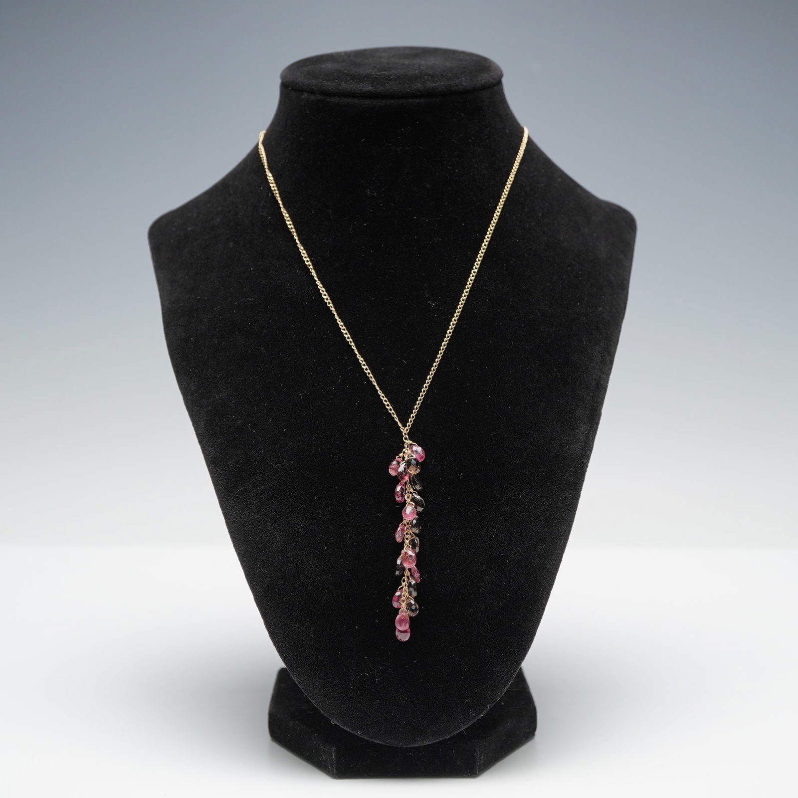 14K Gold Pink and Brown Gemstone Drop Necklace: Necklace composed of a fine 14K gold chain suspending a vertical drop of faceted pink and brown gemstones. Each stone is briolette-cut and wire-wrapped to form a cascading cluster that moves freely. T