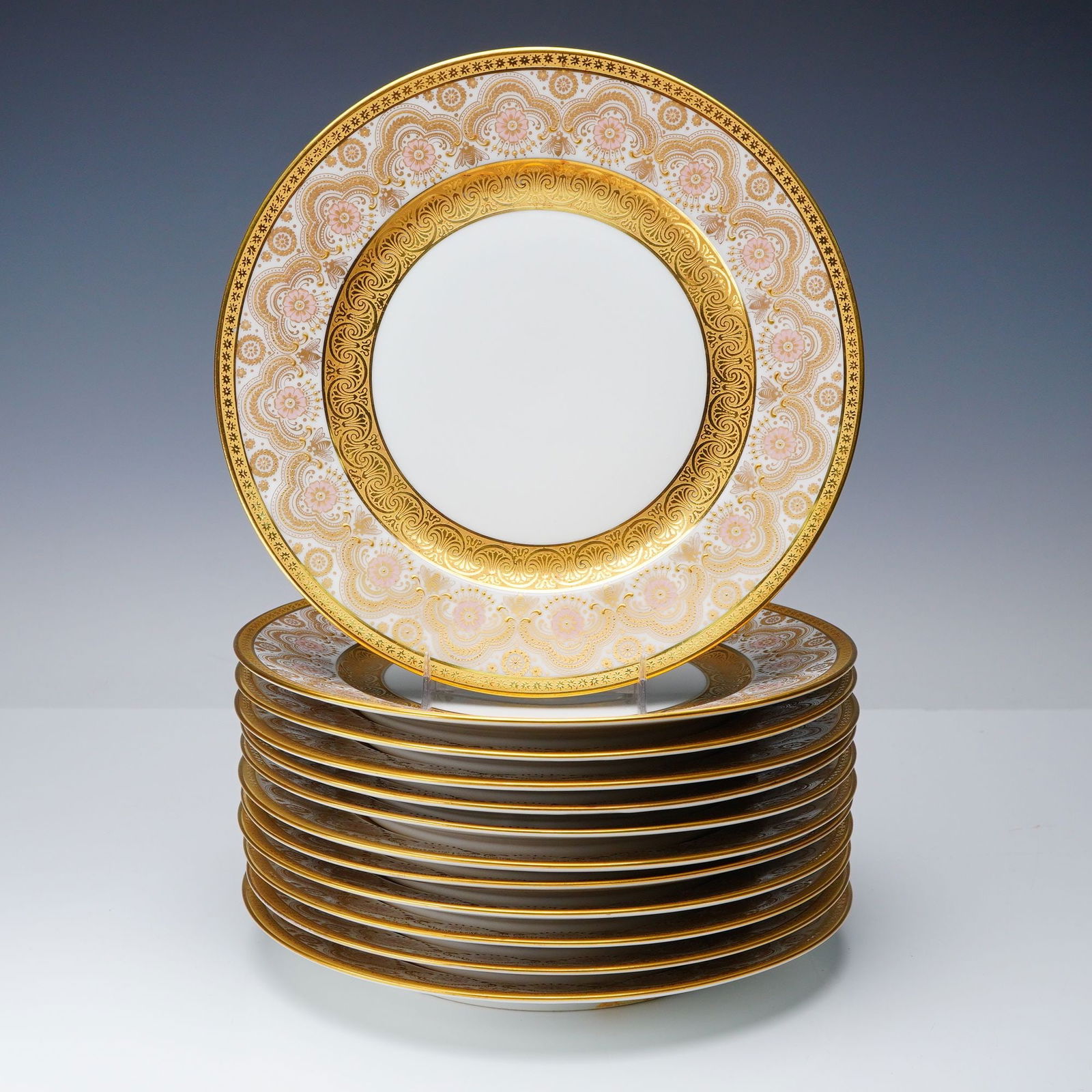 12pc William Guerin & Co. Limoges Gilt Floral and Bee Dinner Plates: This group of twelve Limoges porcelain plates displays a unified pattern distinguished by a wide gilt border of scrolling motifs, stylized floral elements, and small bee figures worked into the design