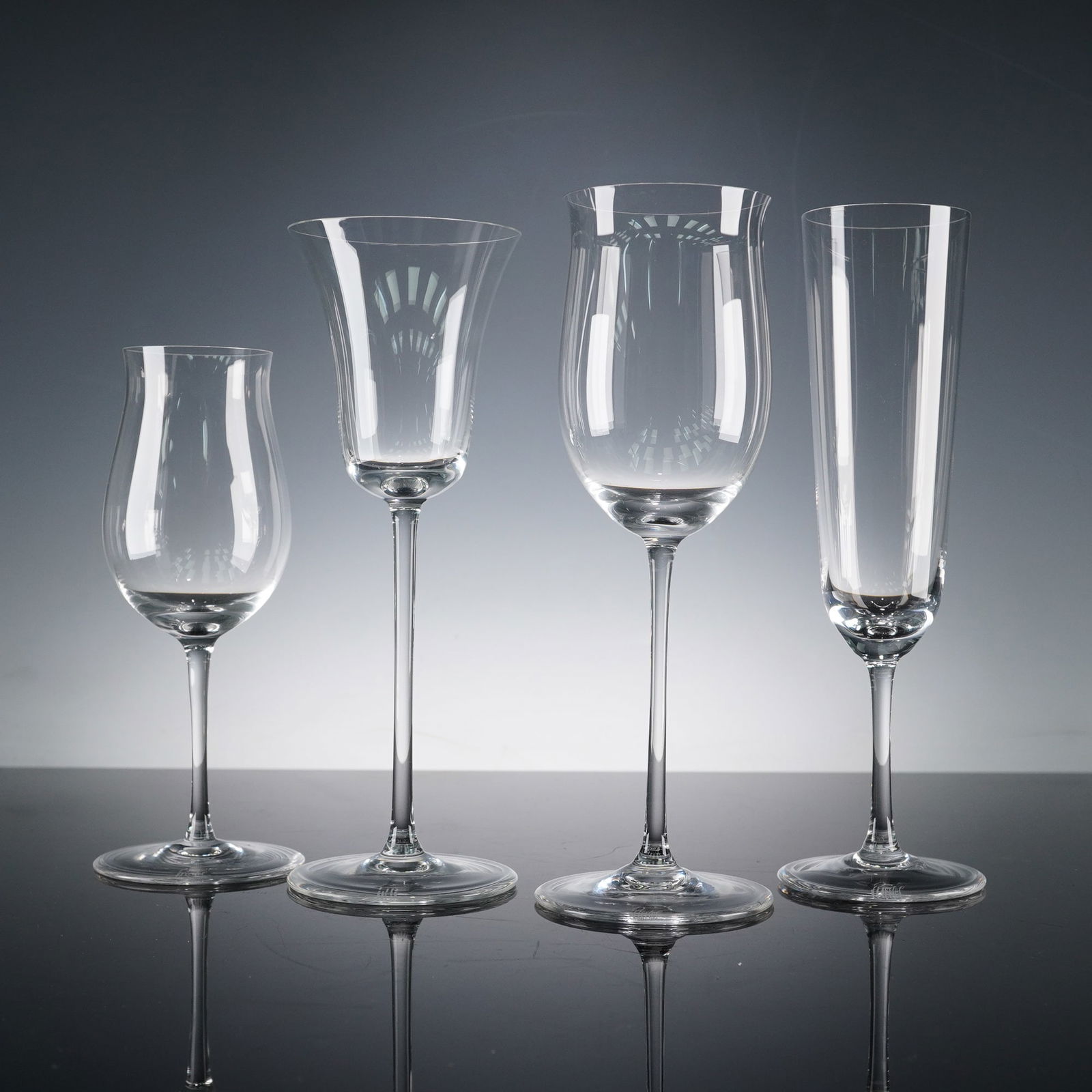 4pc Riedel Crystal Sommeliers Wine Glasses: A refined collection of four Riedel crystal stemware pieces, each designed to enhance the character of specific beverages. The fluted champagne glass features a tall, narrow bowl ideal for preserving