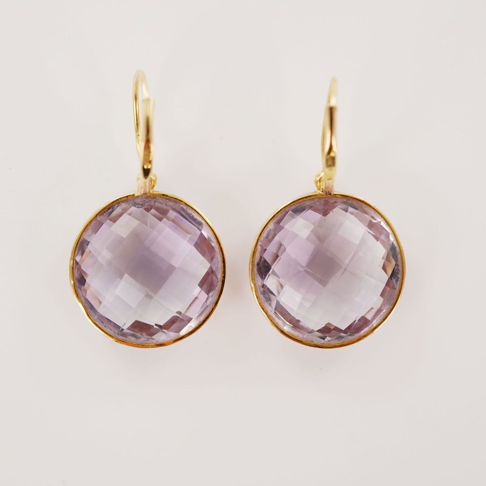 14KP Gold Purple Faceted Glass Drop Earrings: Each earring features a round faceted purple glass stone set in a polished gold bezel, attached to curved ear wires marked 14KP. The stones are uniformly cut with grid faceting and secured in smooth f
