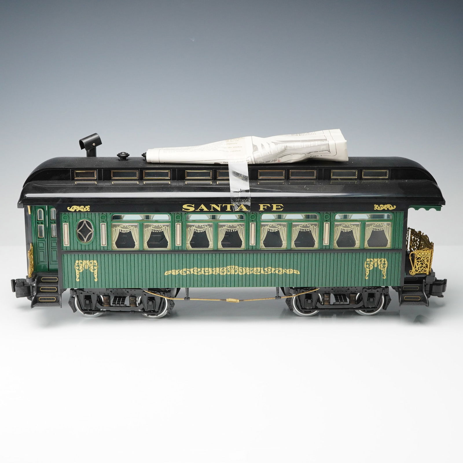 REA Santa Fe Coach Passenger Car Electric Train Model: Vintage REA (Railway Express Agency) Santa Fe Coach Passenger Car electric train model in classic green and black colorway with gold decorative detailing. Features ornate brass-tone end railings, mold