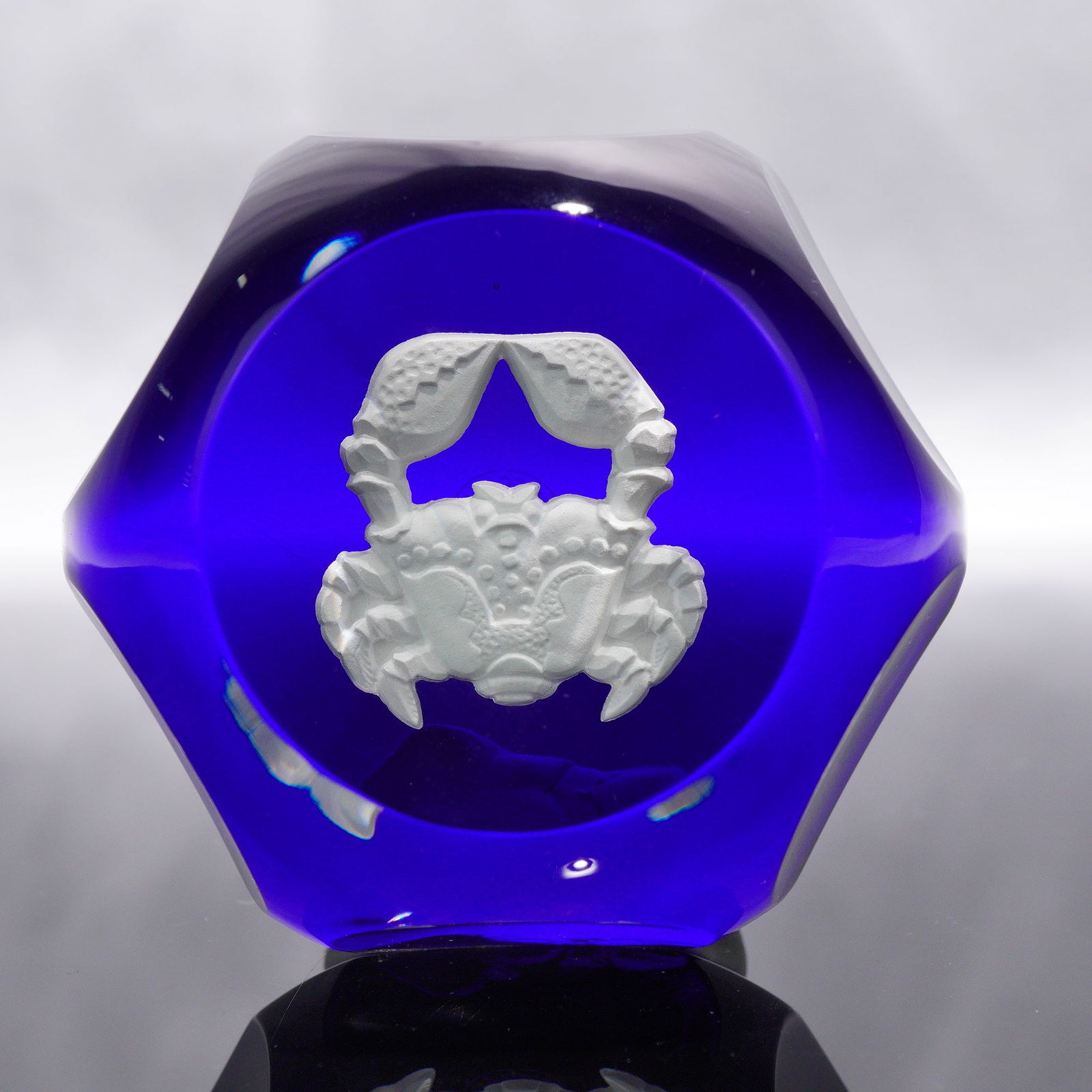 Baccarat Faceted Cobalt Glass Sulphide Paperweight, Crab Motif: A Baccarat faceted cobalt glass sulphide paperweight. This piece features a detailed, three-dimensional white or frosted crab motif encapsulated within its clear and cobalt blue glass body. The exteri