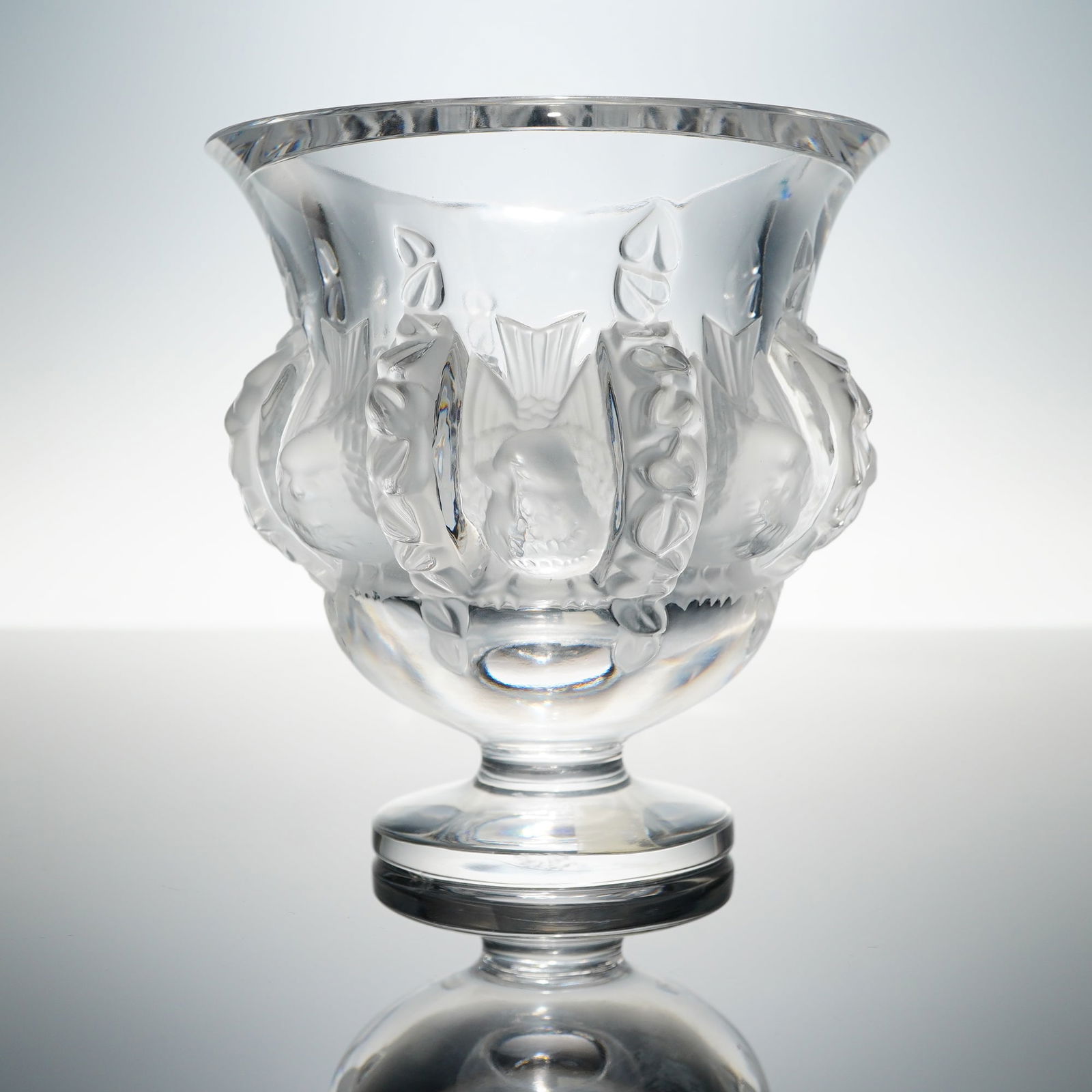 Lalique France Dampierre Molded Crystal Vase: A single molded crystal vase identified as the "Dampierre" pattern by Lalique. The piece features a globular body rising to a wide flared rim, supported by a short pedestal base. The surface is decora