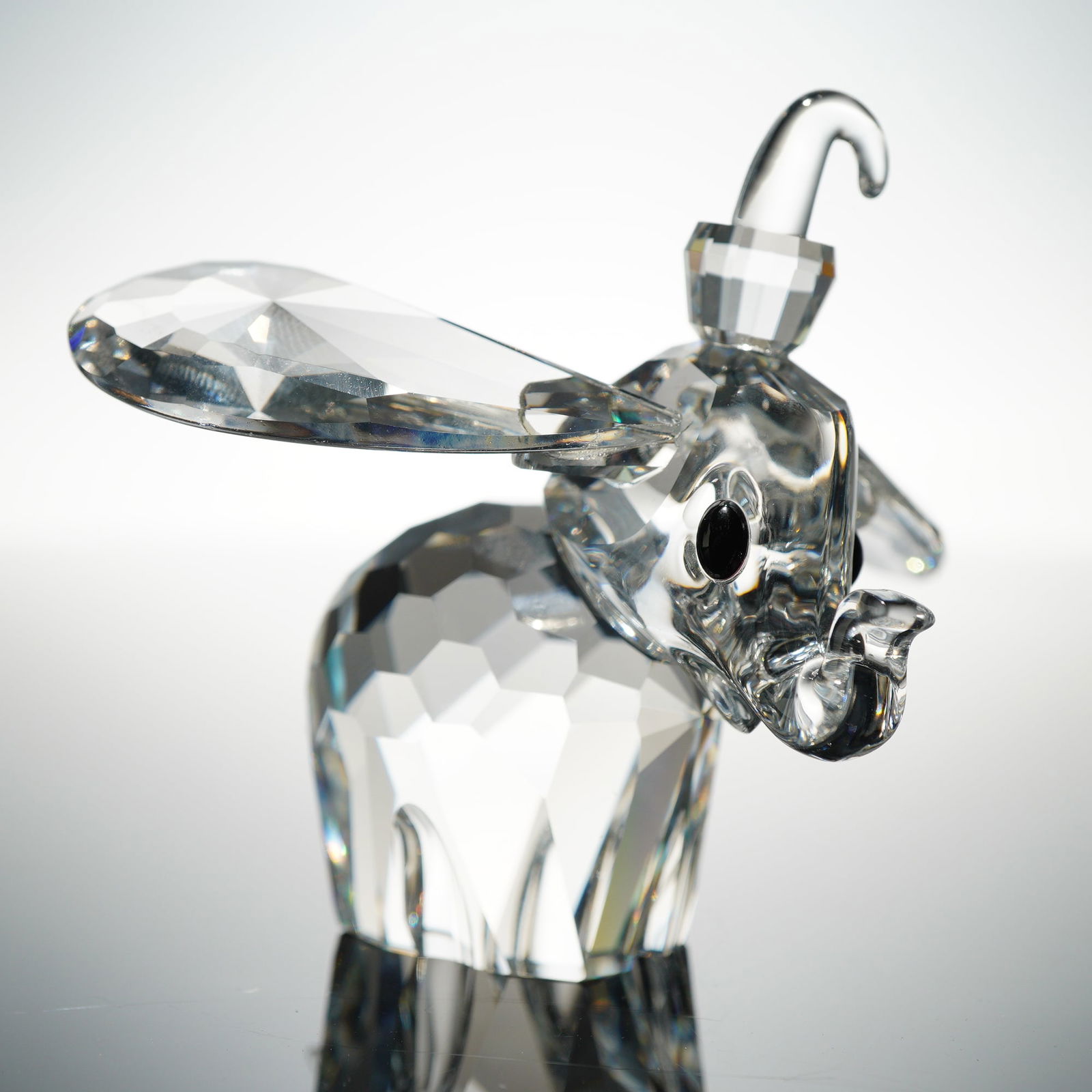 Swarovski Disney Crystal Figurine, Dumbo: A Swarovski Disney Dumbo 'Black Eyes' crystal figurine, model number 7640NR100, released in 1990. The piece is crafted from clear, faceted cut crystal, depicting a stylized elephant with large ears an