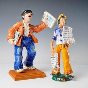 A Pair of Stylized European Ceramic Newsboy Figurines