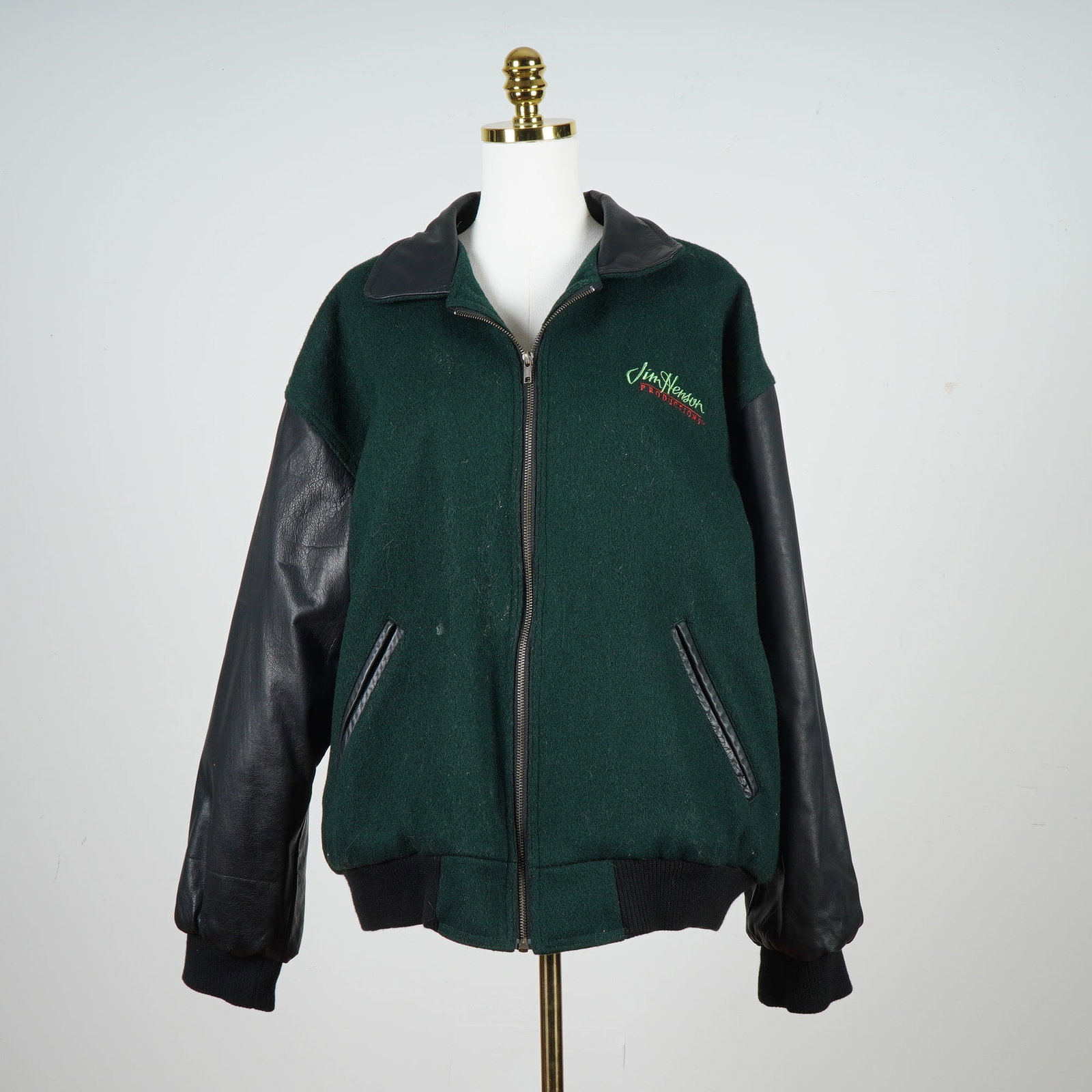 Jim Henson Productions Letterman Jacket, Kermit the Frog: Dark green and black Jim Henson Productions letterman-style jacket, made by Identity Inc. in collaboration with Arrow Leathercare. The jacket features a green wool body with black leather sleeves, col