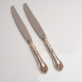 A Pair of Ornate Sterling Silver Handle and Stainless Steel Dinner Knives