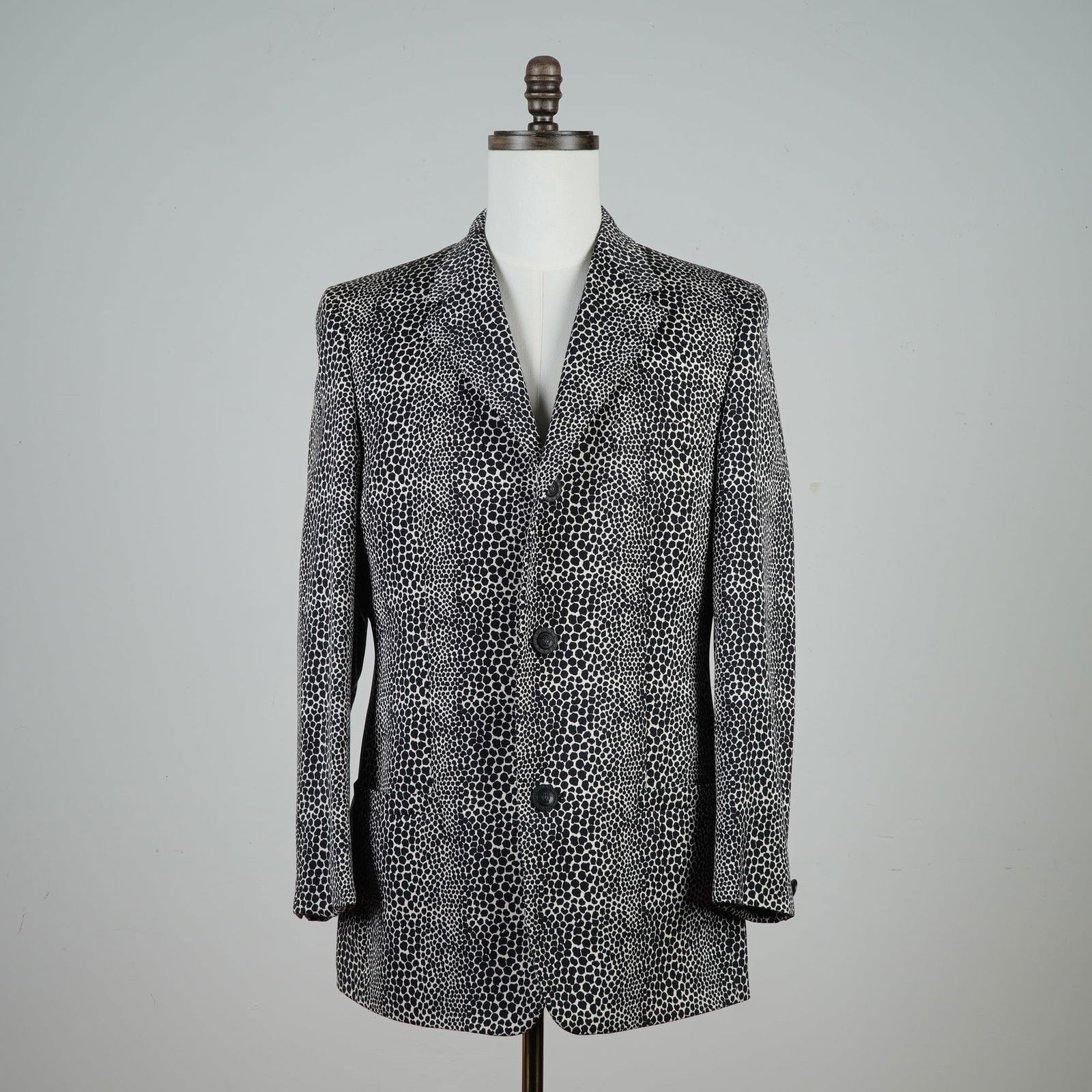 Gianni Versace Men's Blazer, Black and White Patterned: A tailored black and white patterned blazer by Gianni Versace, made in Italy. The jacket features a bold irregular dot motif across a structured silhouette, with a notched lapel, two-button front clos