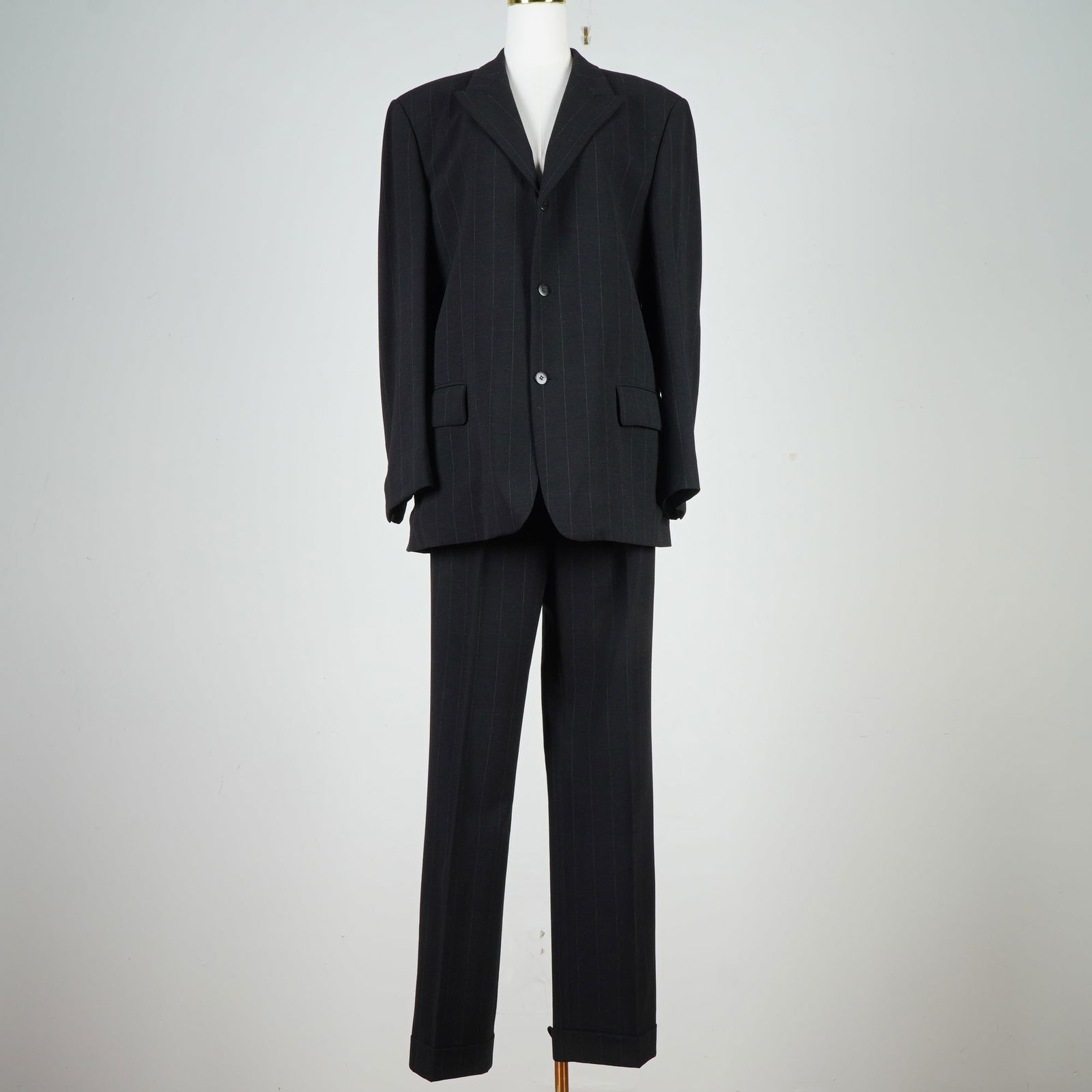 Gianni Versace Men's Wool Suit, Pinstripe: Two-piece suit by Gianni Versace in black wool with a fine gray pinstripe. The single-breasted jacket features a notched lapel, two-button closure, and flap pockets. Matching trousers have a straight-