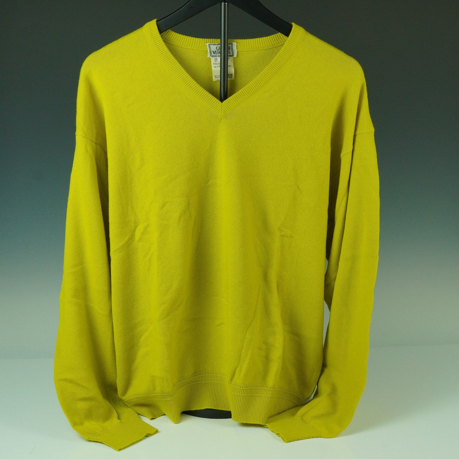 Gianni Versace Yellow Cashmere V-Neck Sweater: A bold addition to any luxury wardrobe, this Gianni Versace V-neck sweater is rendered in vibrant yellow and expertly tailored in Italy from 100% pure cashmere. It features a rib-knit neckline, cuffs,