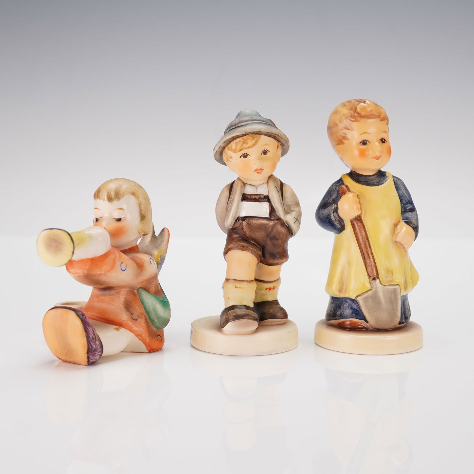 3pc Goebel Hummel Porcelain Figurines and Candle Holder: Charming group of three Goebel Hummel porcelain pieces featuring one figurine that also functions as a candle holder. Included is Garden Treasures, the M I Hummel Club Membership Figurine of 1989-99,