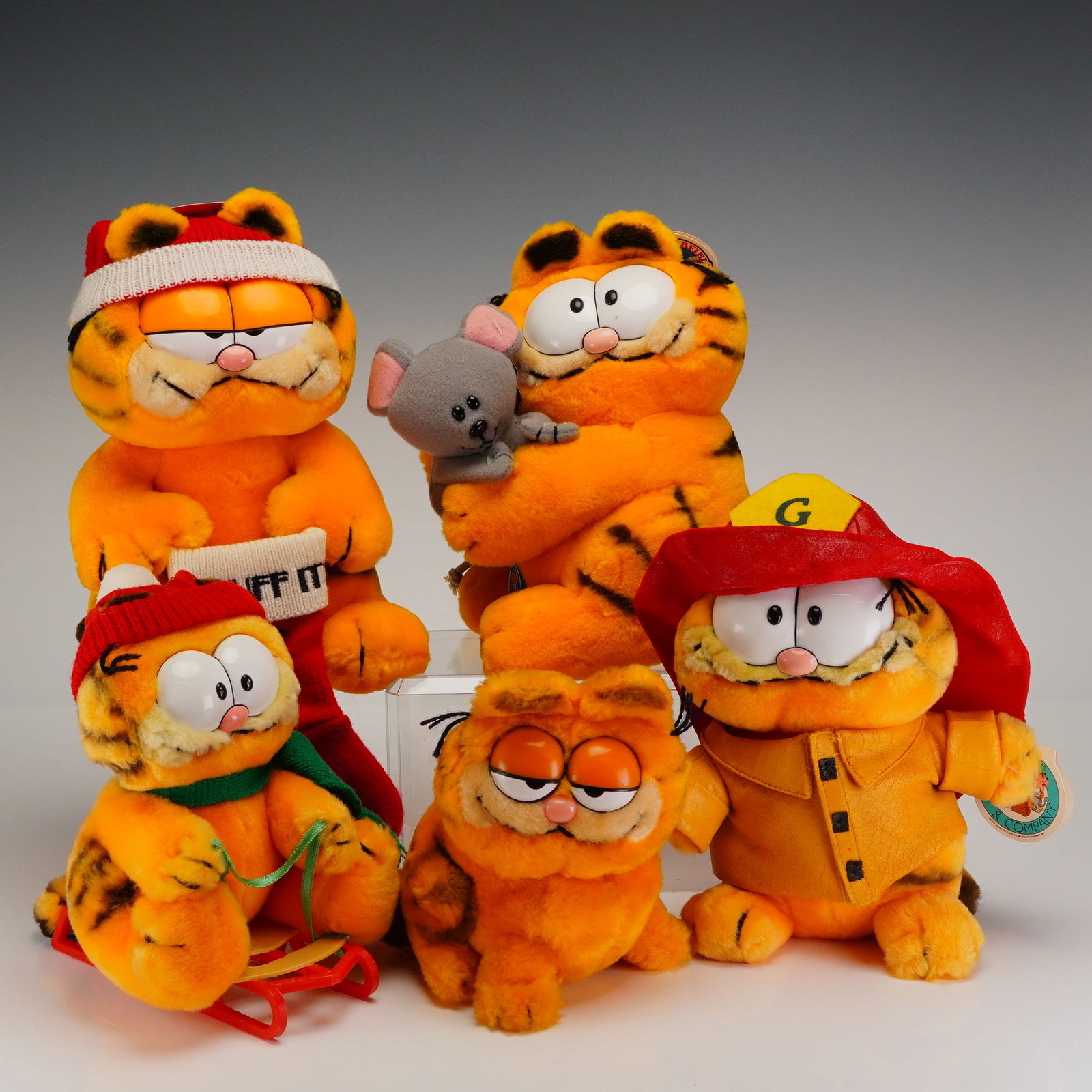 A Collection of 5 R. Dakin & Company Vintage Garfield Plush Toys: A collection of five vintage Garfield plush stuffed toys manufactured by R. Dakin & Company. The figures are constructed from orange and black synthetic plush fabric with plastic facial features. The