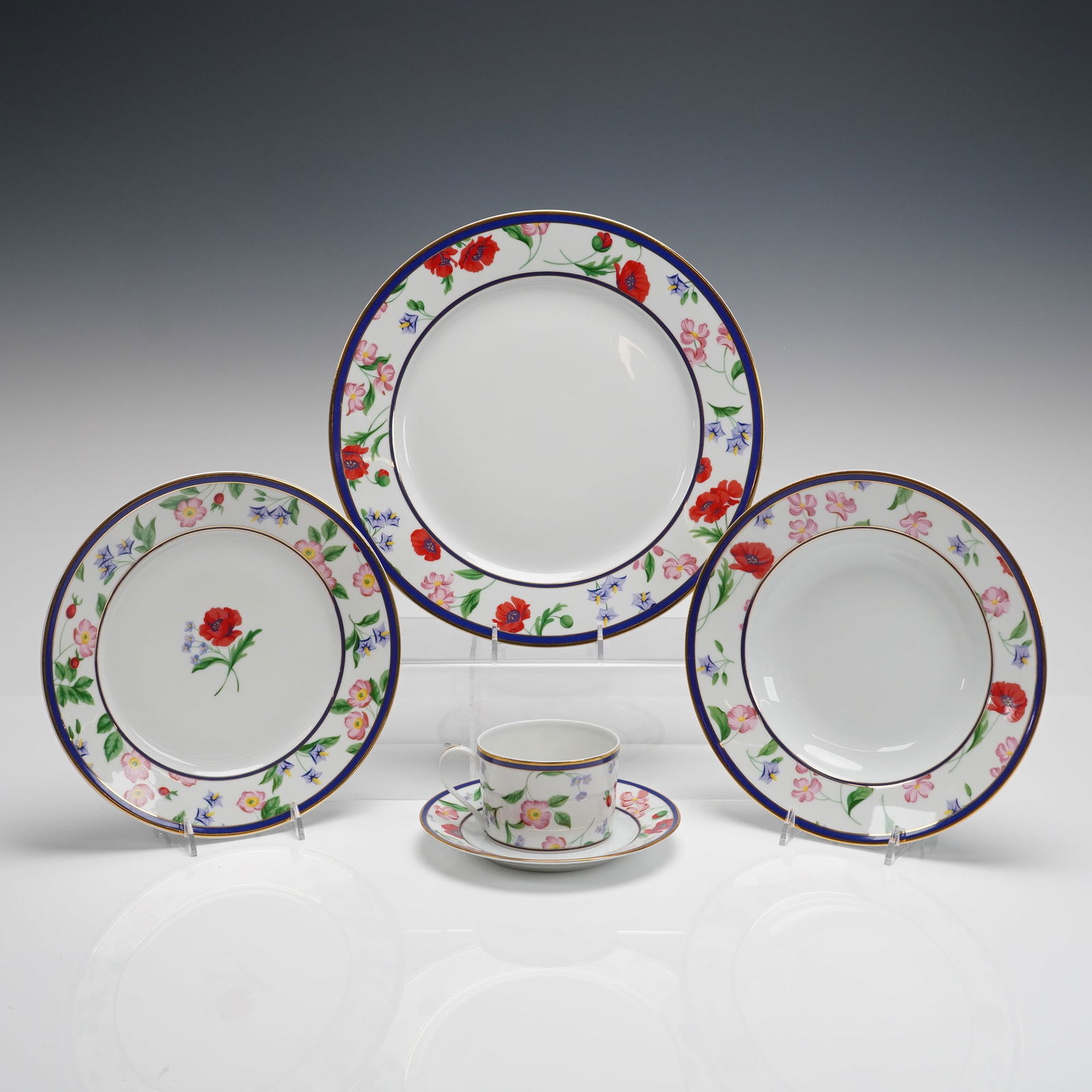 Coll. of 5 Tiffany & Co. American Garden Limoges France Dinnerware Pieces: A collection of 5 pieces of Tiffany & Co. Limoges France porcelain dinnerware in the "American Garden" pattern. The set includes three various-sized plates, one teacup, and one saucer. The white porce