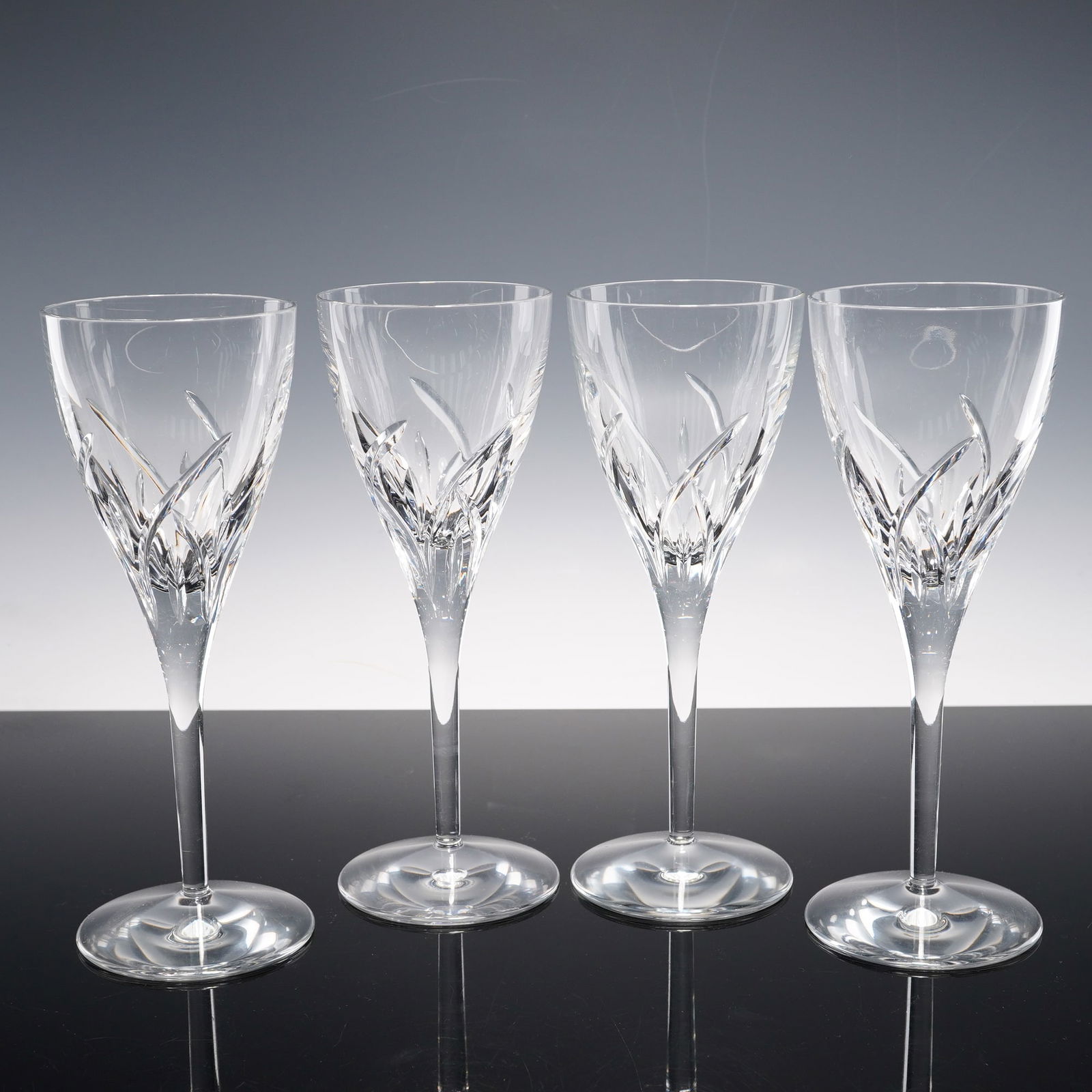 4pc Waterford Crystal Wine Glasses, Merrill: Set of four wine glasses in the Merrill pattern featuring overlapping upward cuts resembling stylized blades rising from the lower bowl to a clear upper section. Each is set on a tapering stem and cir