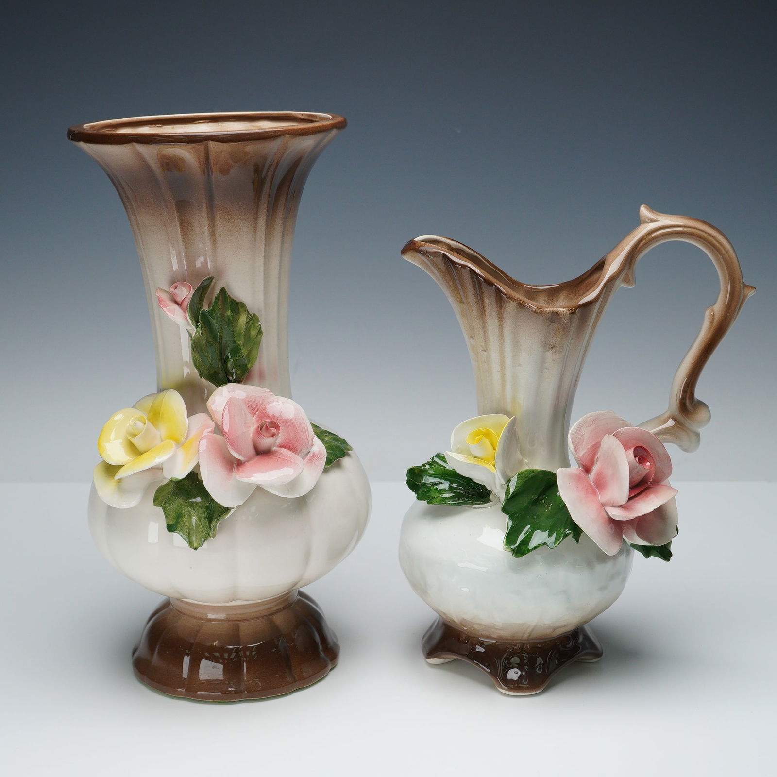 2pc Nuova Capodimonte Vintage Floral Pitcher & Vase: This elegant Italian porcelain set includes one fluted vase and one matching handled pitcher, each adorned with hand-applied, delicately sculpted roses in soft pink and yellow hues surrounded by rich