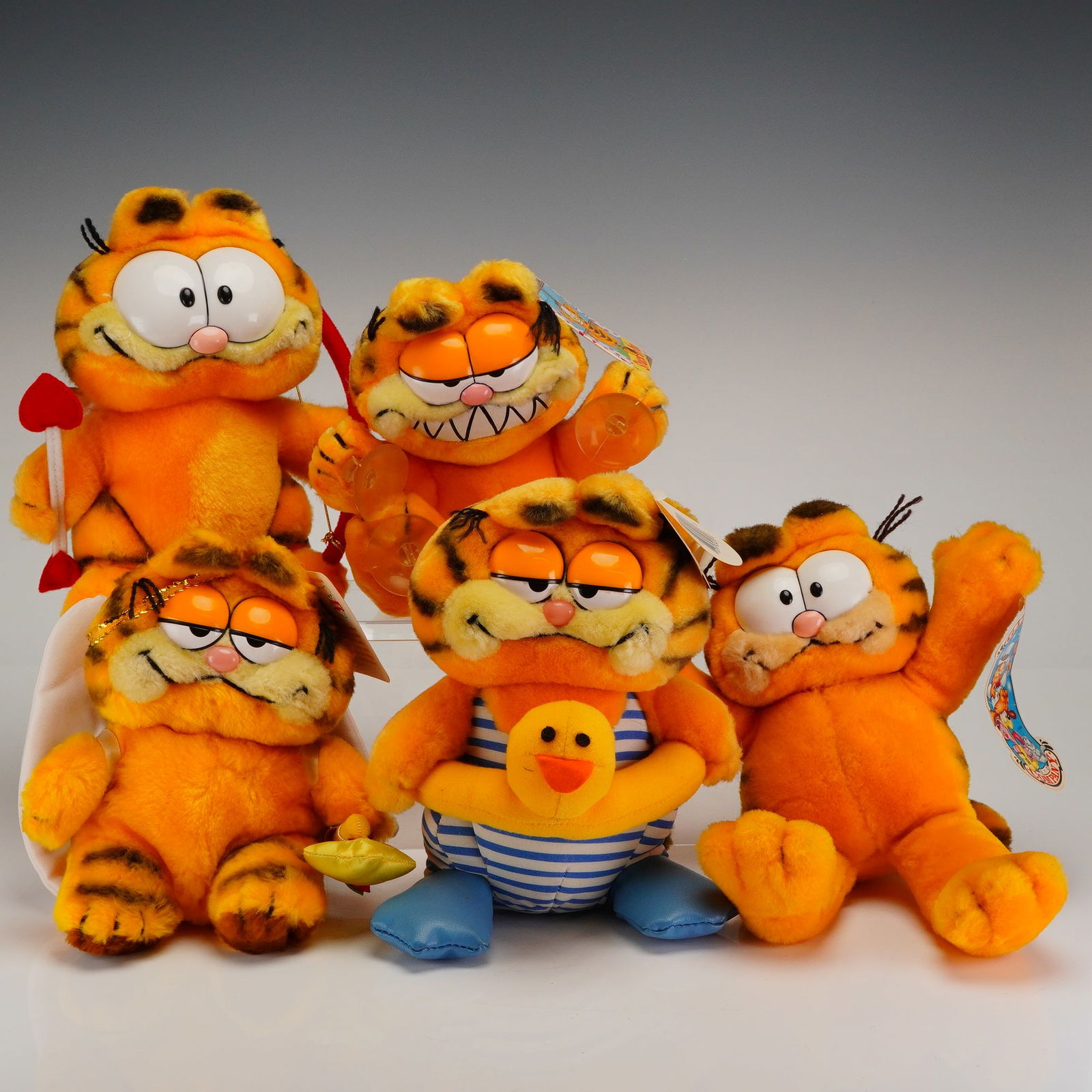 A Collection of 5 Vintage R. Dakin & Company Garfield Stuffed Plush Toys: A collection of five vintage Garfield stuffed toys manufactured by R. Dakin & Company. The figures are constructed primarily of orange and black striped plush fabric with plastic facial features, cons