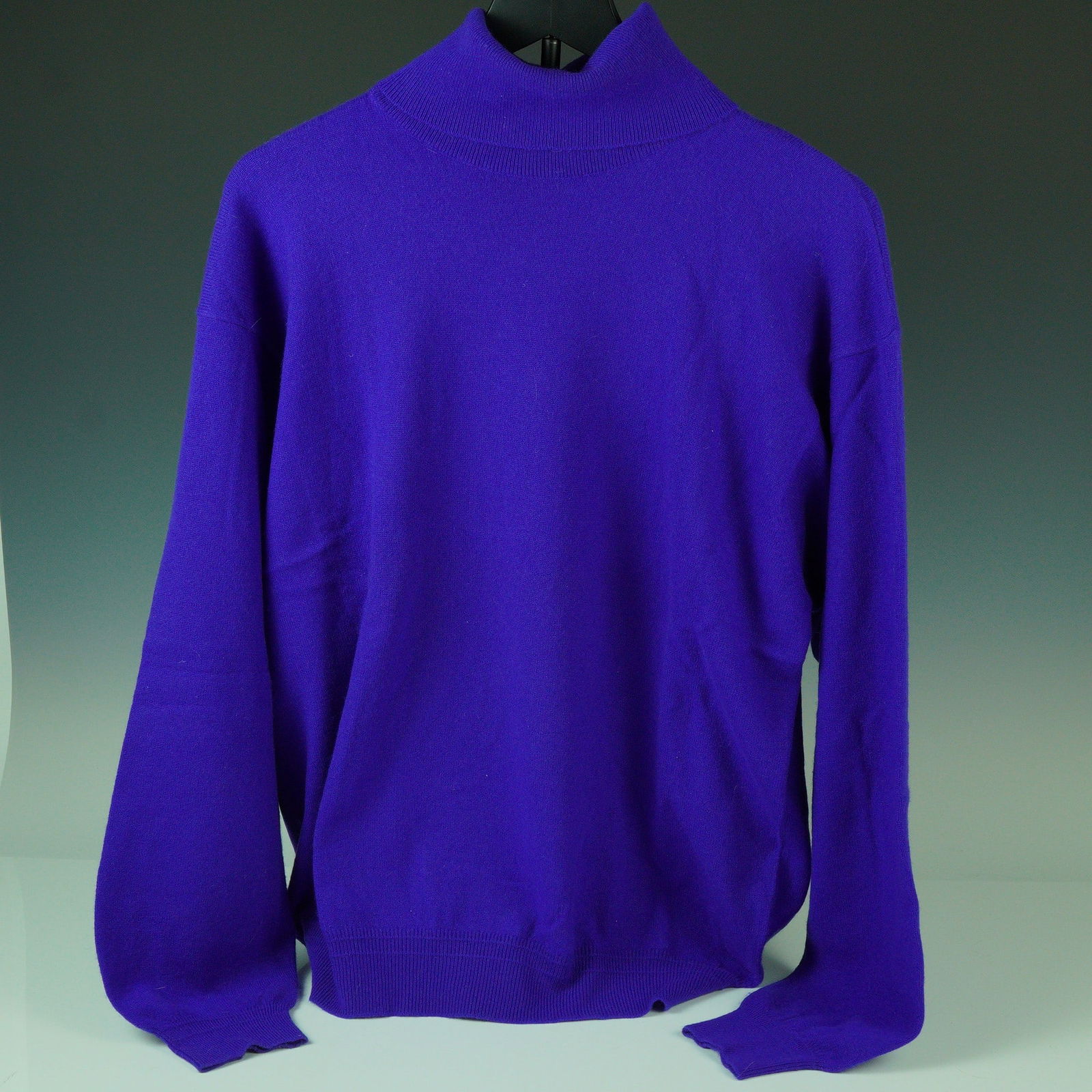 Gianni Versace Purple Cashmere Turtleneck Sweater: Striking in color and refined in construction, this vintage Gianni Versace turtleneck sweater is crafted entirely from luxurious 100% cashmere in a rich royal purple hue. Featuring a ribbed high neckl