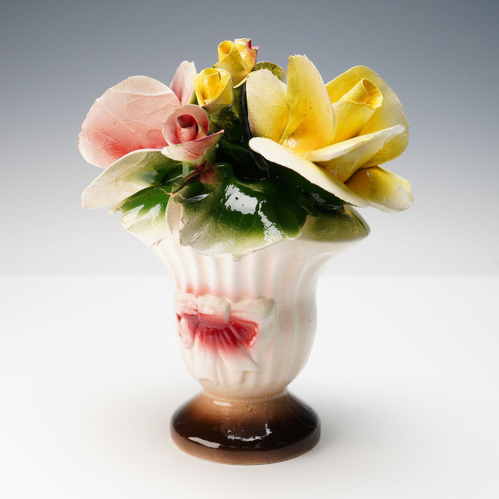Nuova Capodimonte Italian Porcelain Floral Centerpiece: Charming Nuova Capodimonte porcelain floral centerpiece, featuring a fluted pedestal vase with sculpted roses and foliage in soft pastel shades of yellow, pink, and green. The vase itself is finished