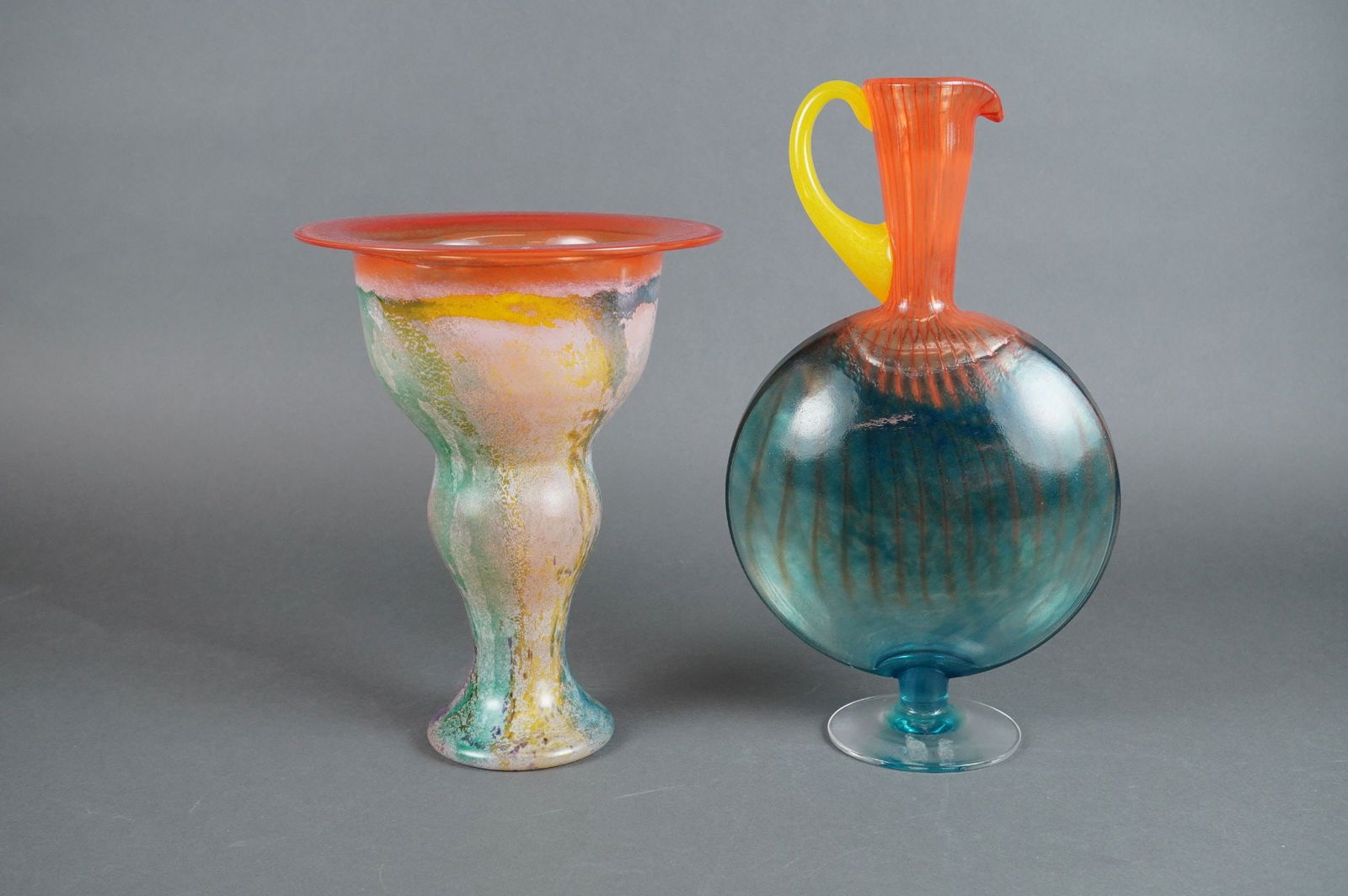 A Pair of Kosta Boda Kjell Engman Bon Bon Series Art Glass Vessels: A pair of Kjell Engman designed art glass vessels for Kosta Boda, part of the Bon Bon series. The collection consists of two distinct pieces, both exhibiting vibrant coloration and complex blown glass