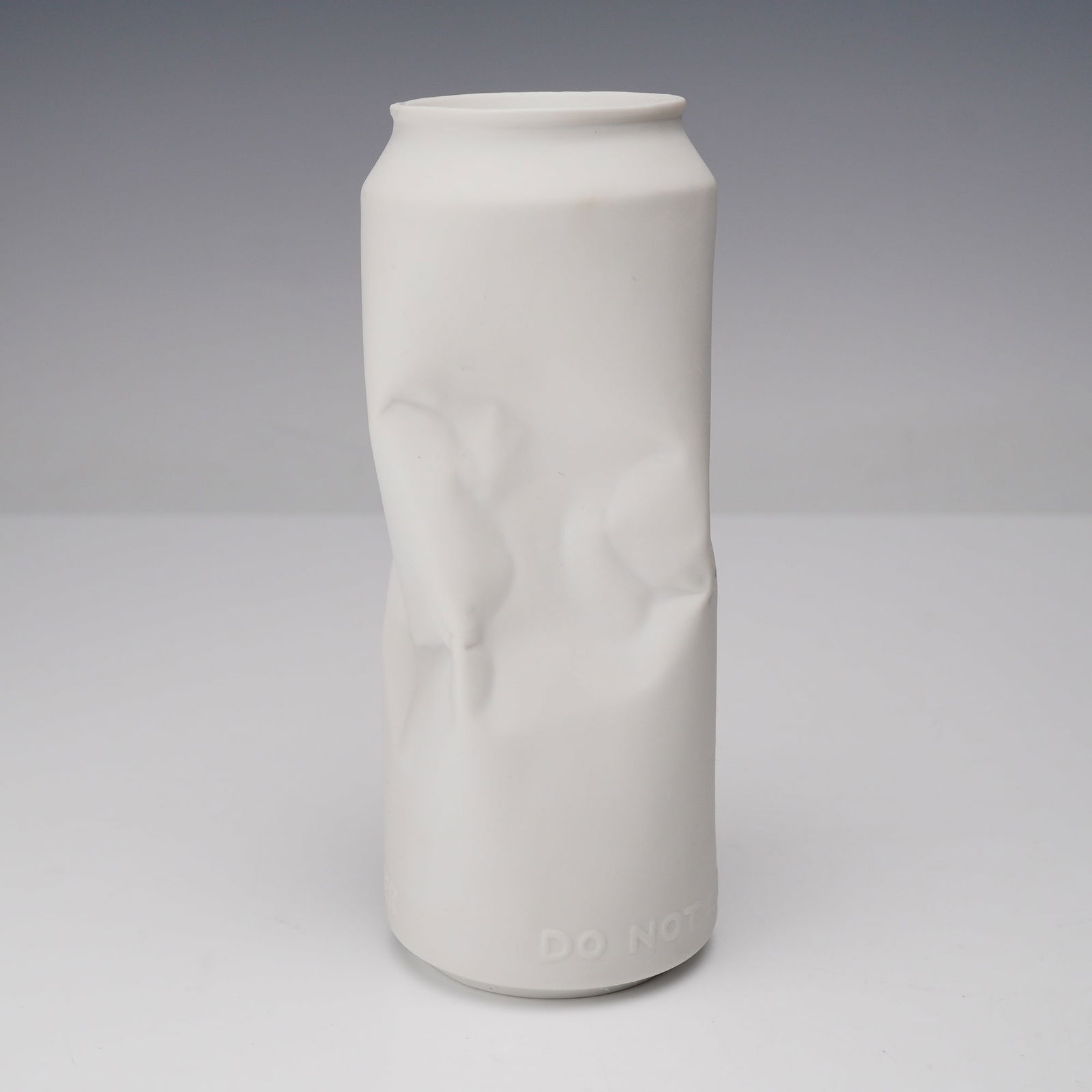 Rosenthal Do Not Litter Porcelain Crushed Can Vase: This contemporary sculptural object is crafted from white bisque porcelain, intentionally formed to resemble a crumpled aluminum beverage can. From the Do Not Litter collection. It features a matte fi