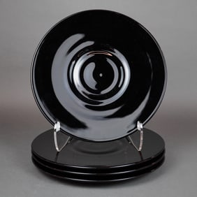 A Collection of Four Black Glass Chargers