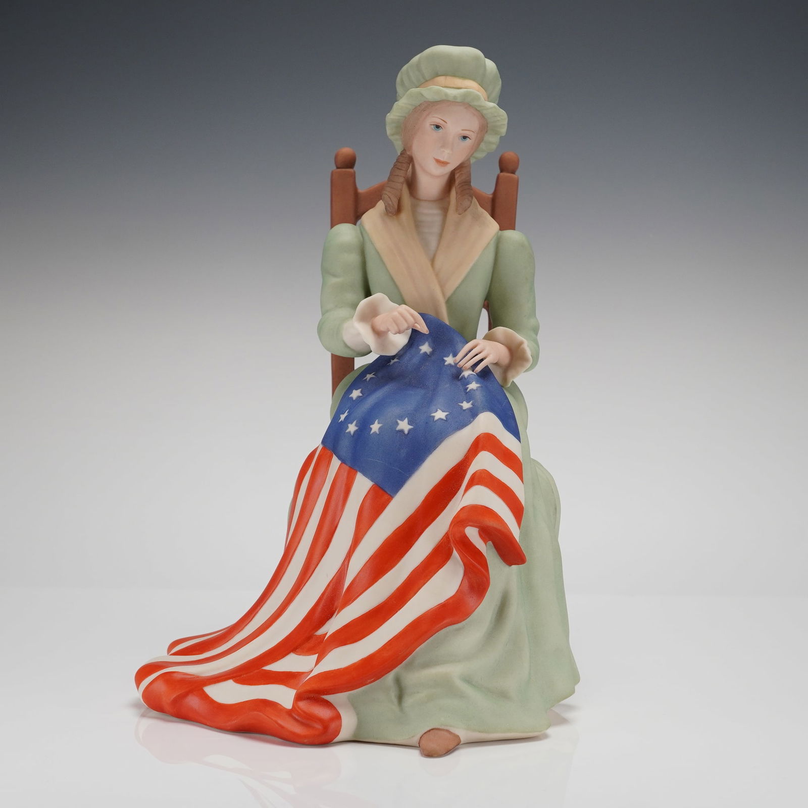 Laszlo Ispanky Limited Edition Goebel Betsy Ross Porcelain Figurine: A limited edition Goebel Betsy Ross Figurine, sculpted by Laszlo Ispanky. The glazed ceramic figurine depicts a seated female figure, historically identified as Betsy Ross, dressed in an 18th-century