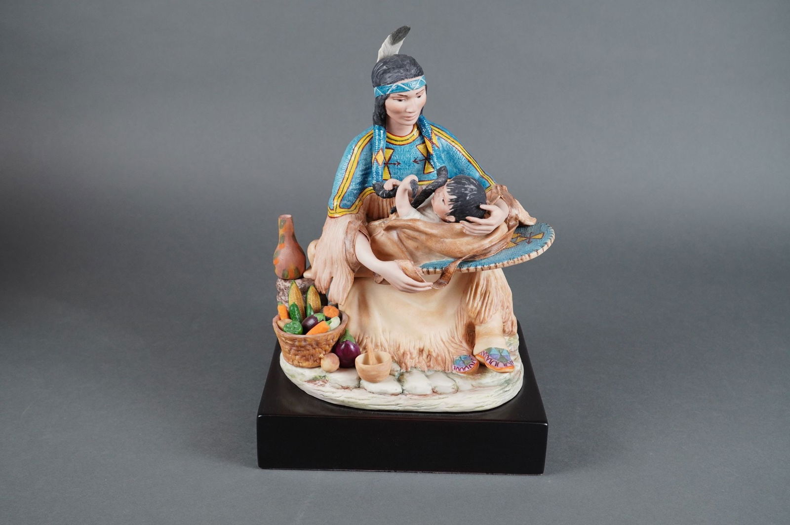 Cybis Porc. Sculpture of a Native American Woman & Infant, Marked #175: A figurative sculpture by Cybis, likely part of their North American Indians Collection. The single item is constructed of cast material, likely porcelain or composite resin, and features intricate ha