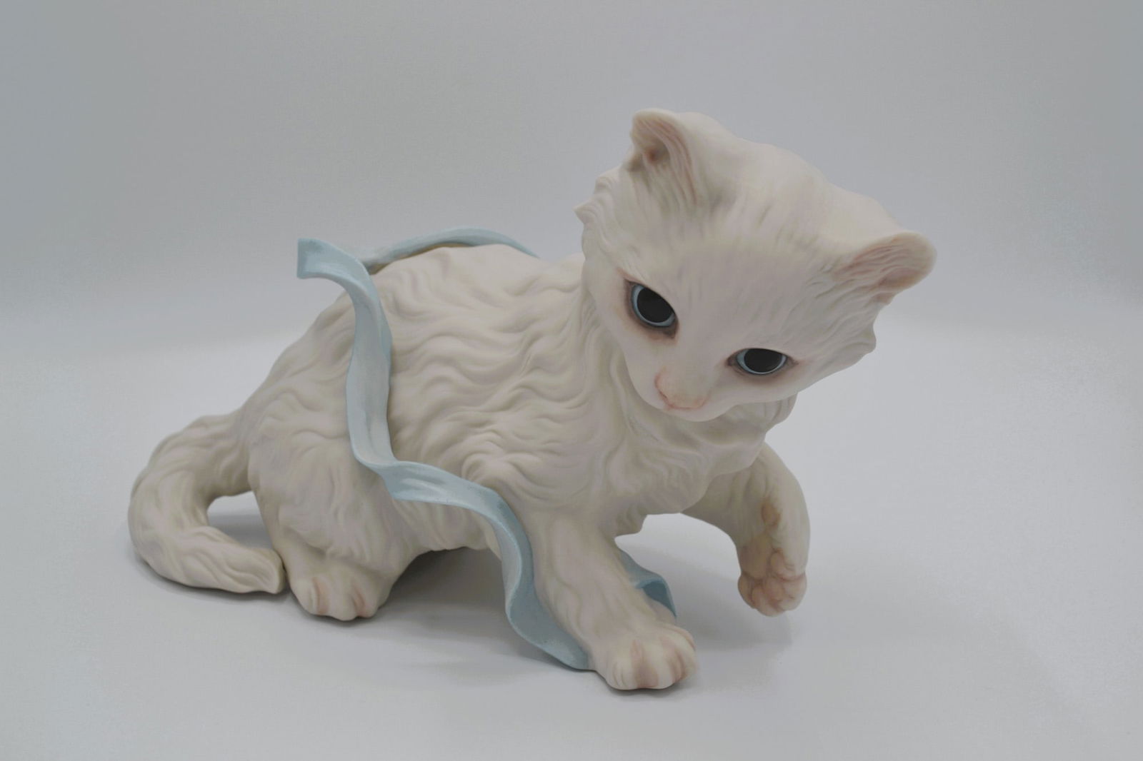 Cybis Porcelain Large Kitten W/Blue Ribbon Sculpture, 1967: Bisque Porcelain Decorated, hand created, hand painted by the Artisans of the Cybis Studio in Trenton, NJ, USA. Featuring the Kitten With Blue Ribbon, introduced in 1967. A sold out and closed edition