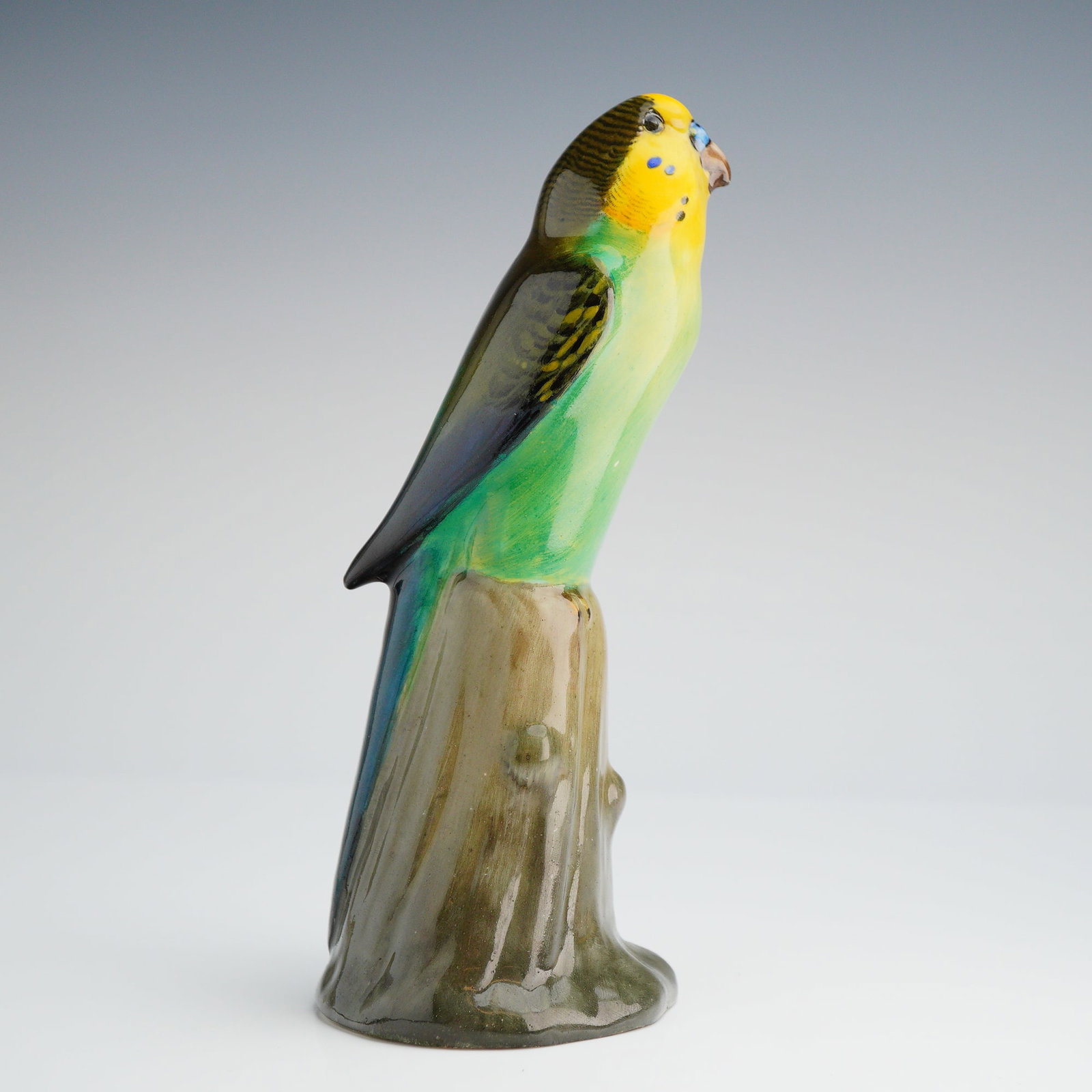 Royal Doulton Figurine, Budgerigar On Tree Stump HN163: A single ceramic figurine manufactured by Royal Doulton, model number HN 163, depicting a Budgerigar or parakeet. The bird is modeled perched atop a simulated wood stump base. The figurine is executed