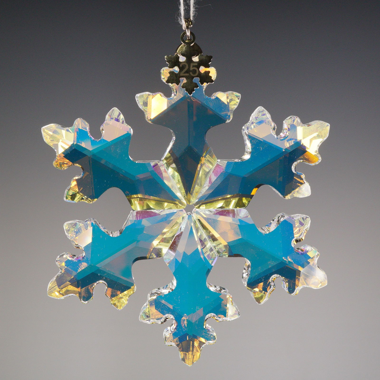 Swarovski 25th Anniversary Limited Edition 2016 Snowflake Ornament: The ornament is constructed from highly faceted iridescent crystal, cut in the shape of a six-pointed snowflake. The snowflake tag is etched with the number 25 on one side and the year 2016 on the rev