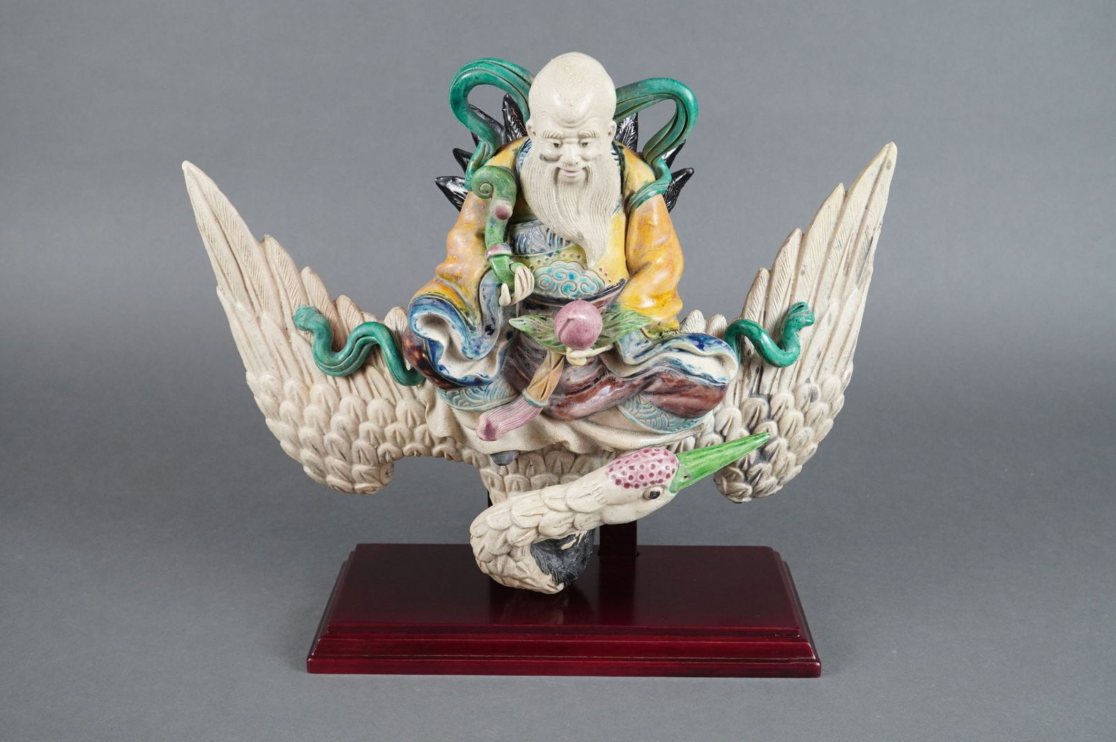 Chinese Polychrome Ceramic Roof Tile Sculpture of Shoulao and Crane: Chinese, Late Qing/Republican Period (Late 19th/Early 20th Century). A highly detailed polychrome ceramic roof tile sculpture depicting Shoulao (God of Longevity), recognizable by his high forehead an