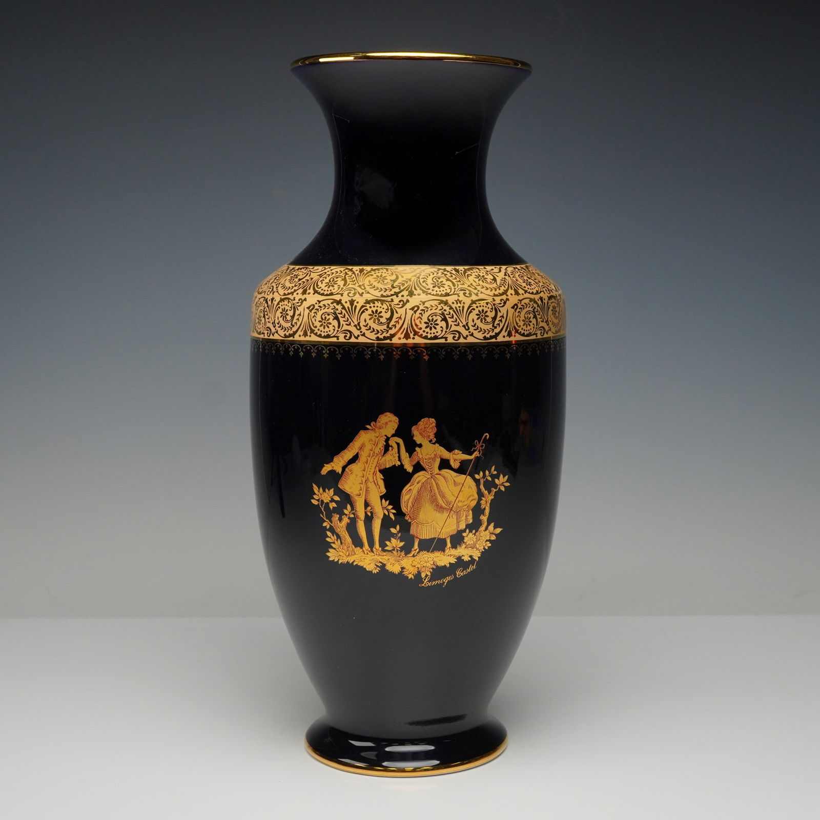 Limoges Castel Cobalt Blue and 22K Gold Vase: A Limoges Castel cobalt'blue porcelain vase with extensive 22K gold decoration, ovoid body, flared rim, gilt scrollwork, and central Rococo figural scene. Base marked LIMOGES CASTEL FRANCE and 22 K GO