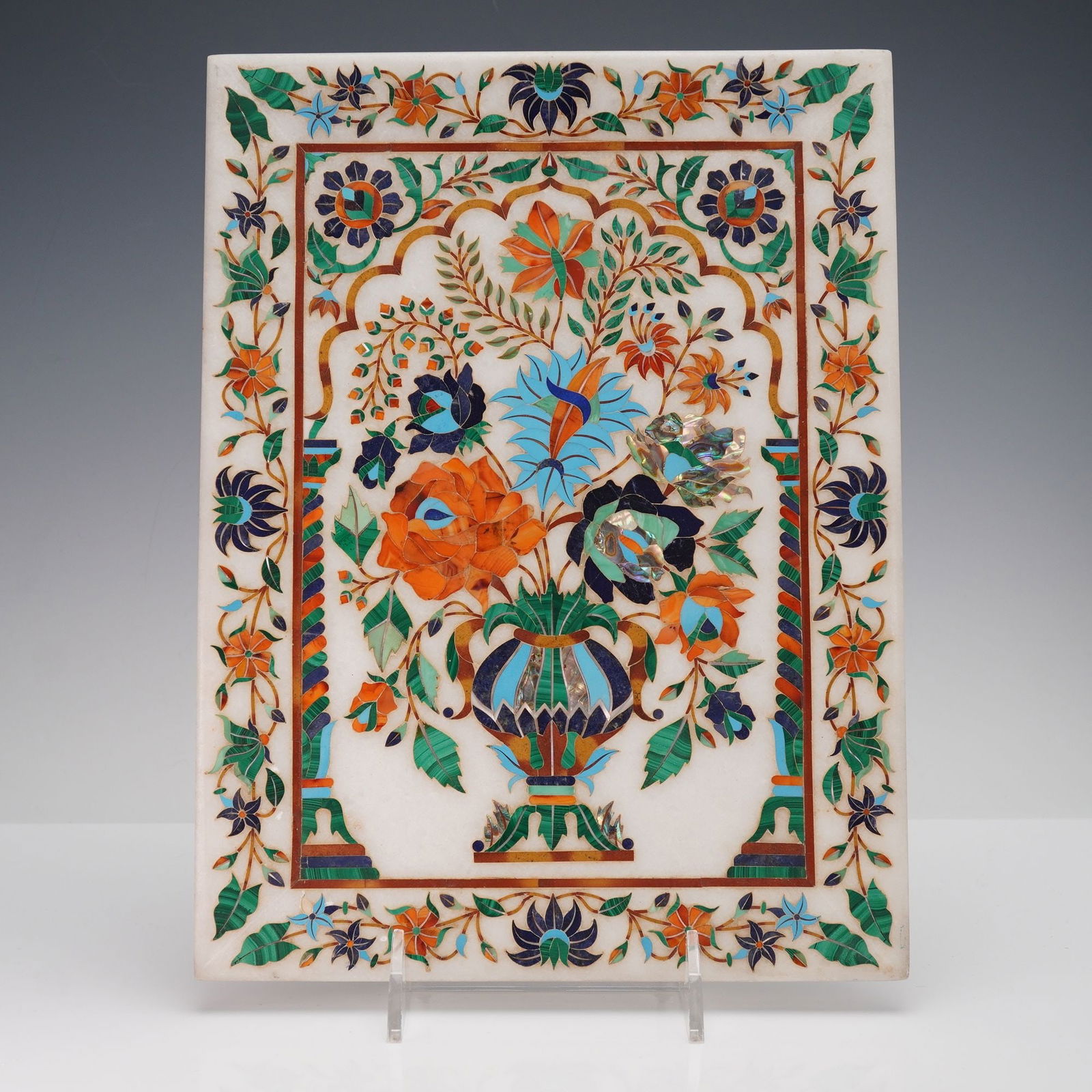 An Indian White Marble Pietra Dura Style Inlaid Floral Panel: A rectangular decorative panel crafted from white marble, featuring intricate floral and foliate designs executed in a colorful hardstone inlay technique, consistent with the Pietra Dura or Mughal sty