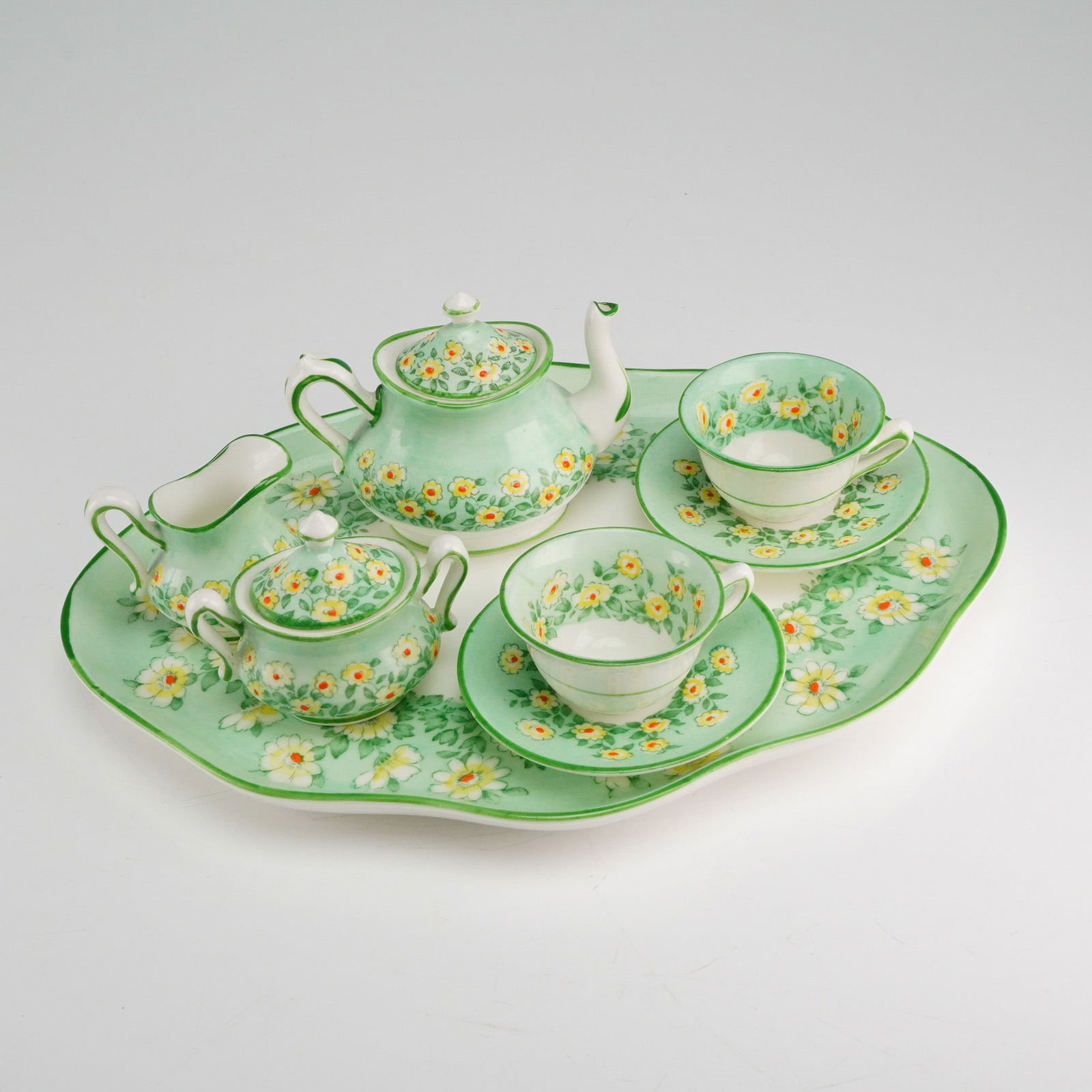 Crown Staffordshire 8-Piece Miniature Tea Set Yellow Daisy Floral Pattern: A collection of 8 individual items constituting a miniature tea service by Crown Staffordshire. The set is constructed from fine bone china and includes one teapot with its associated lid, one handled